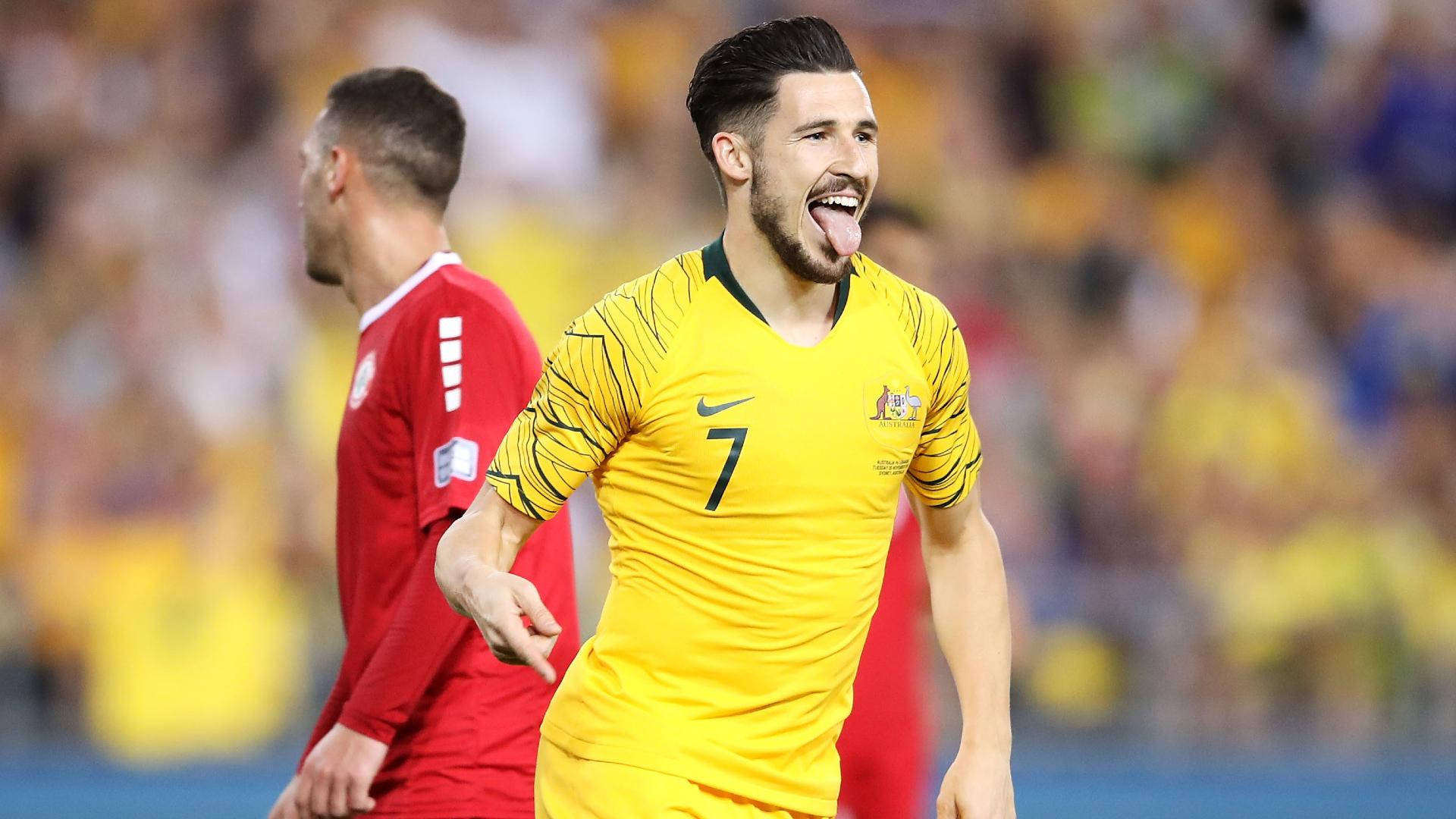 World 桌布 壁紙 — 一位快樂的澳洲足球員身穿黃色7號球衣，在比賽中伸出舌頭慶祝。