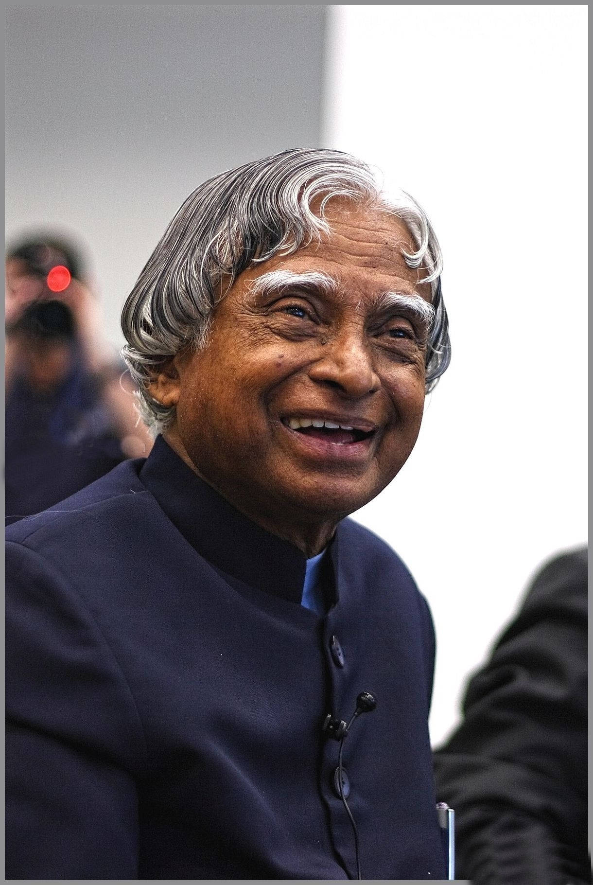 Smile 桌布 壁紙 — 一位快樂的白髮老人穿著深藍色傳統外套，溫暖地微笑。