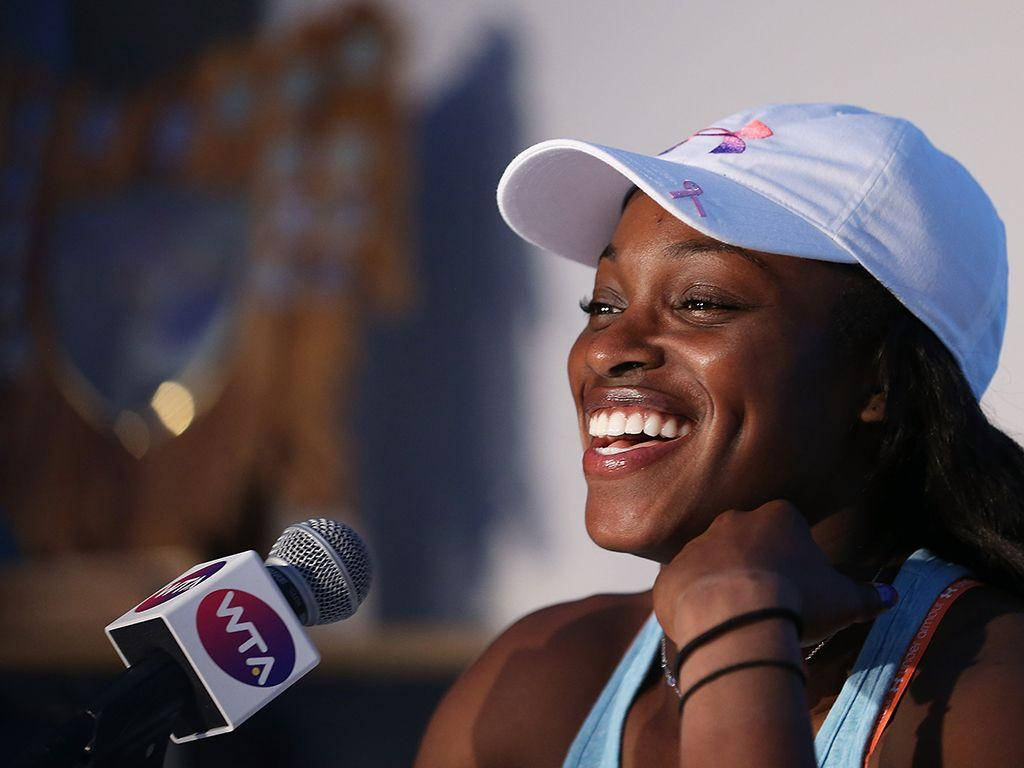 運動 桌布 壁紙 — 一位快樂的網球選手戴著淺藍色帽子，帽上有粉紅色絲帶，對著WTA麥克風說話時笑容滿面。
