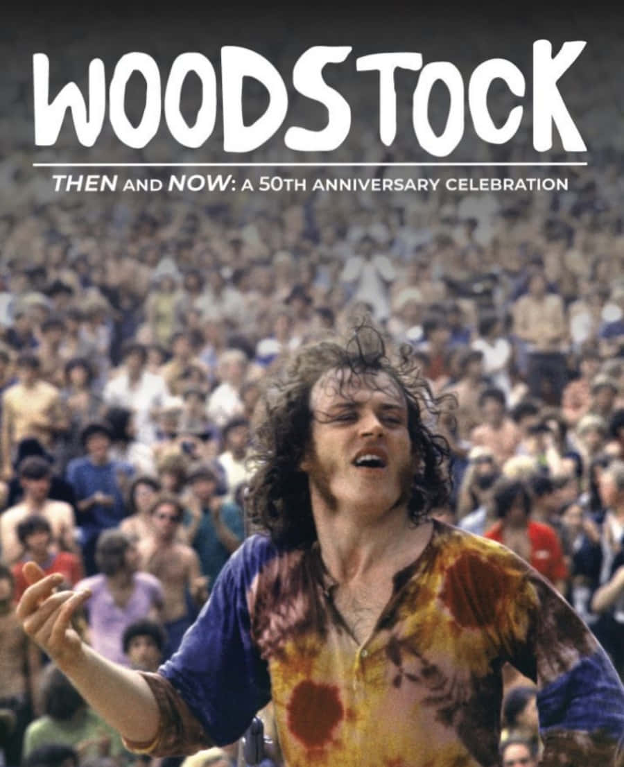 woodstock 桌布 壁紙 — 一位快樂的胡士托音樂節參加者，頭髮蓬亂，身穿紮染襯衫，在明亮的日光下對著大量人群熱情歌唱。