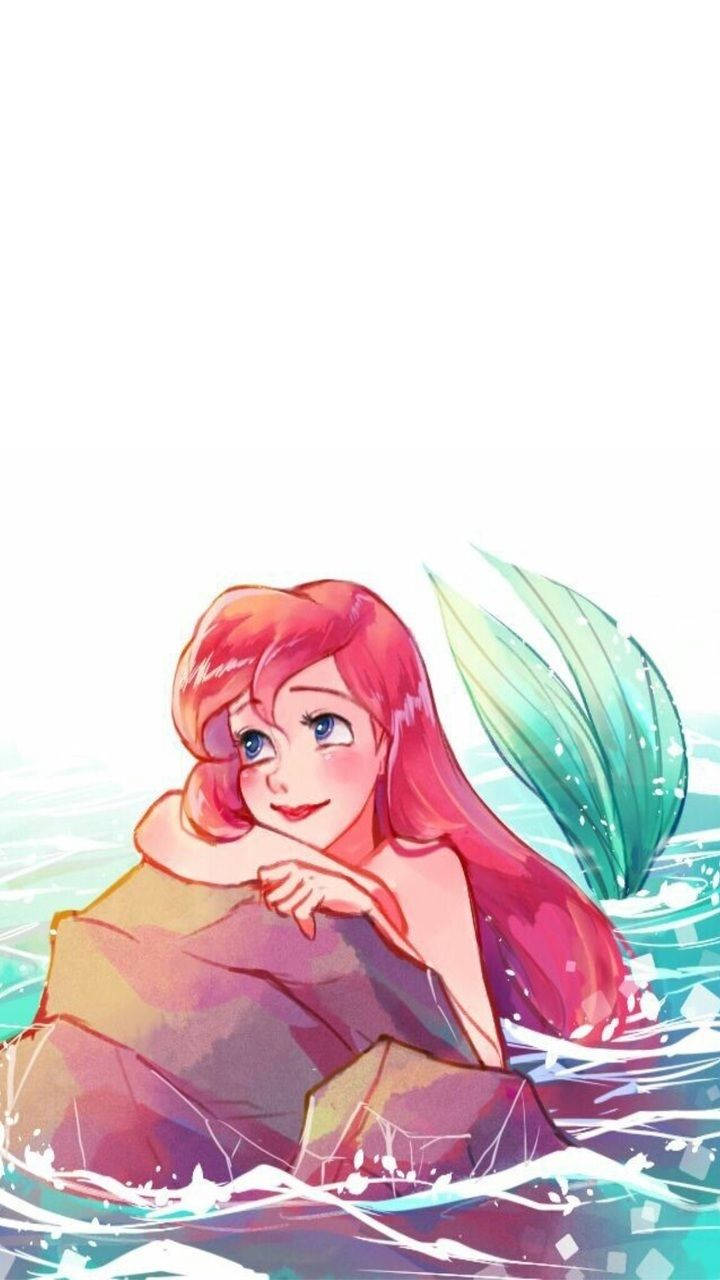 愛麗兒 桌布 壁紙 — 一位快樂的長紅髮綠尾美人魚在明亮的日光下，在閃閃發光的碧綠海水中休息在岩石上。