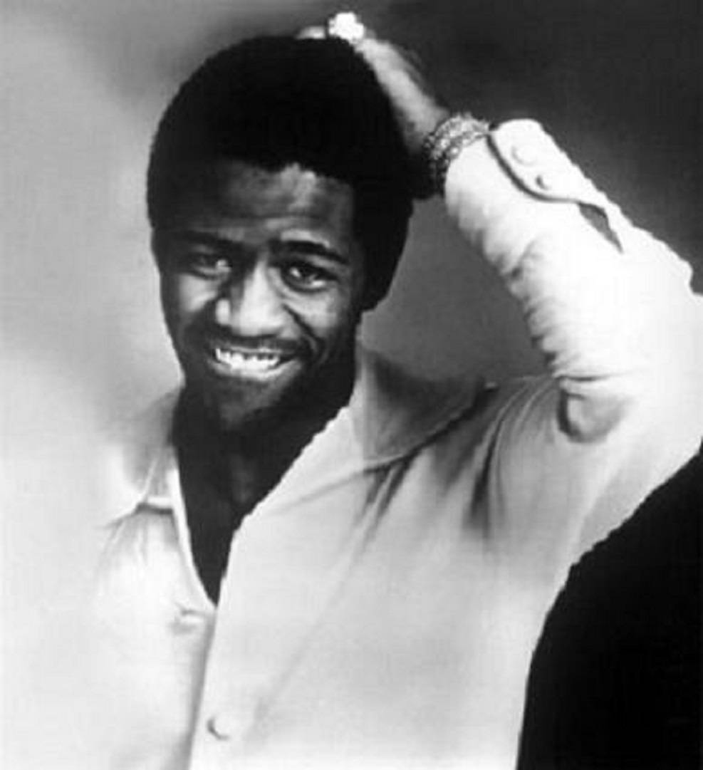 Al Green 桌布 壁紙 — 一位快樂的黑人男子穿著淺色襯衫，在經典工作室肖像中微笑著用手梳理頭髮。