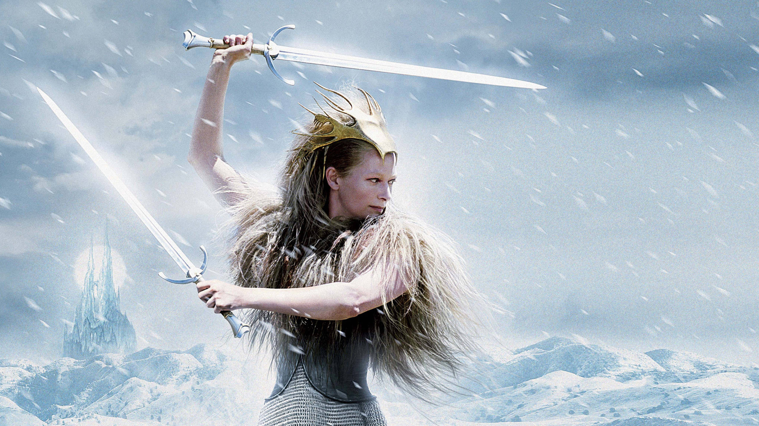 Narnia 桌布 壁紙 — 一位戰士女王在雪景中高舉兩把發光的劍，對抗暴風雨的天空，遠處有一座城堡。