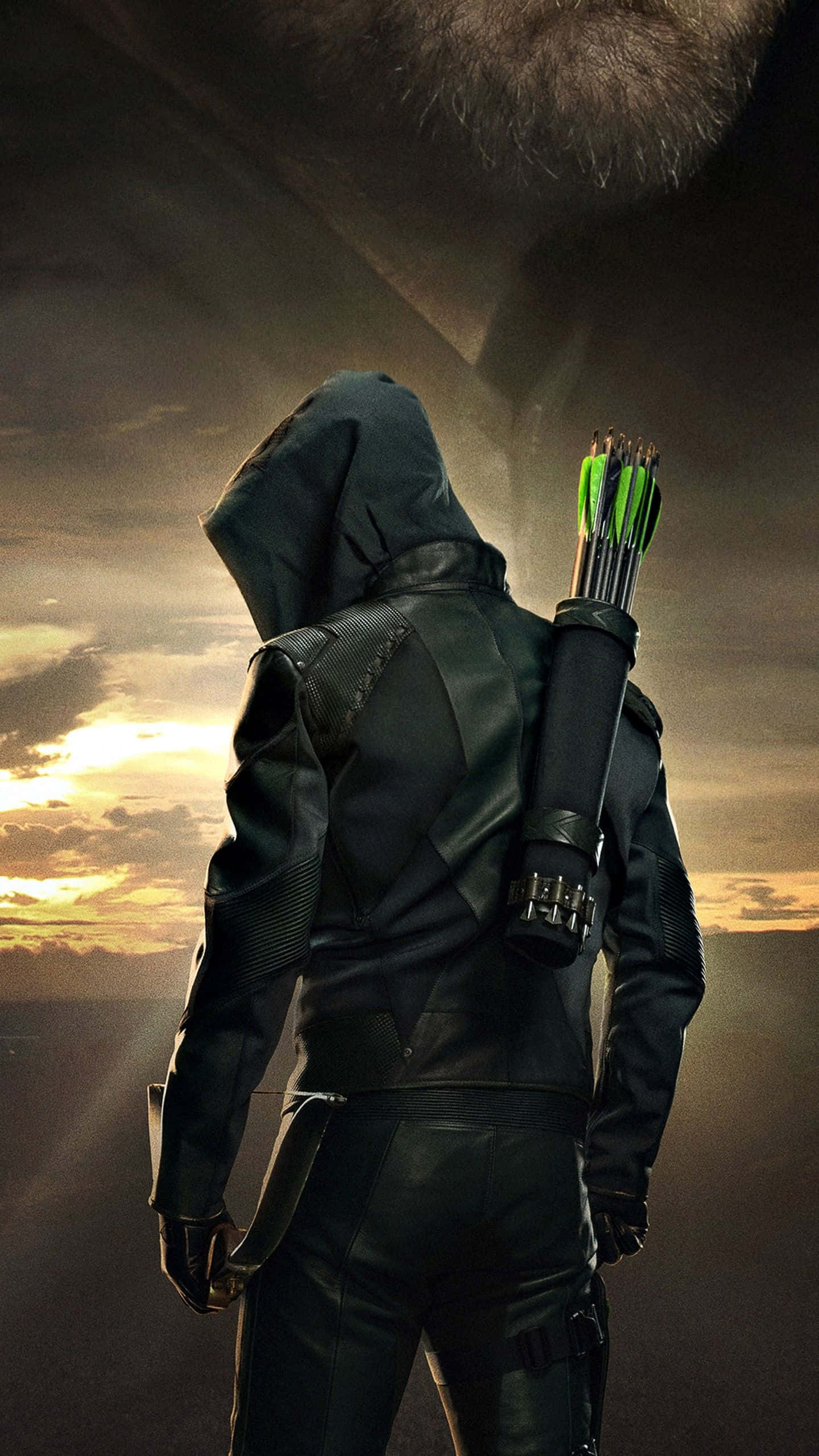 Green Arrow iPhone 桌布 壁紙 — 一位戴兜帽的弓箭手，背著一筒綠色箭矢，站在戲劇性的日落天空前。