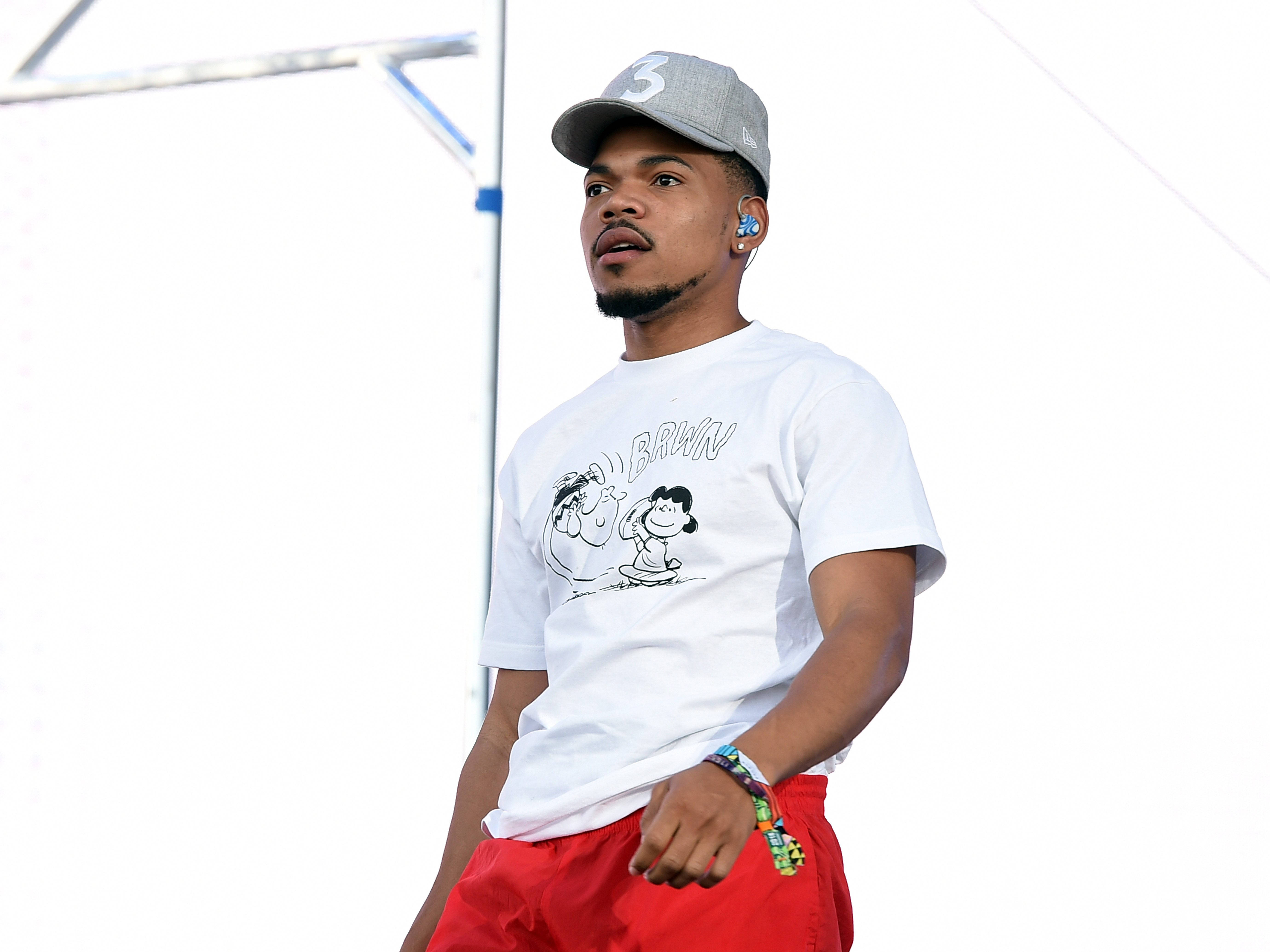 chance 桌布 壁紙 — 一位戴灰色帽子和紅色短褲的年輕男子自信地站著，身穿帶有卡通圖案的白色T恤。