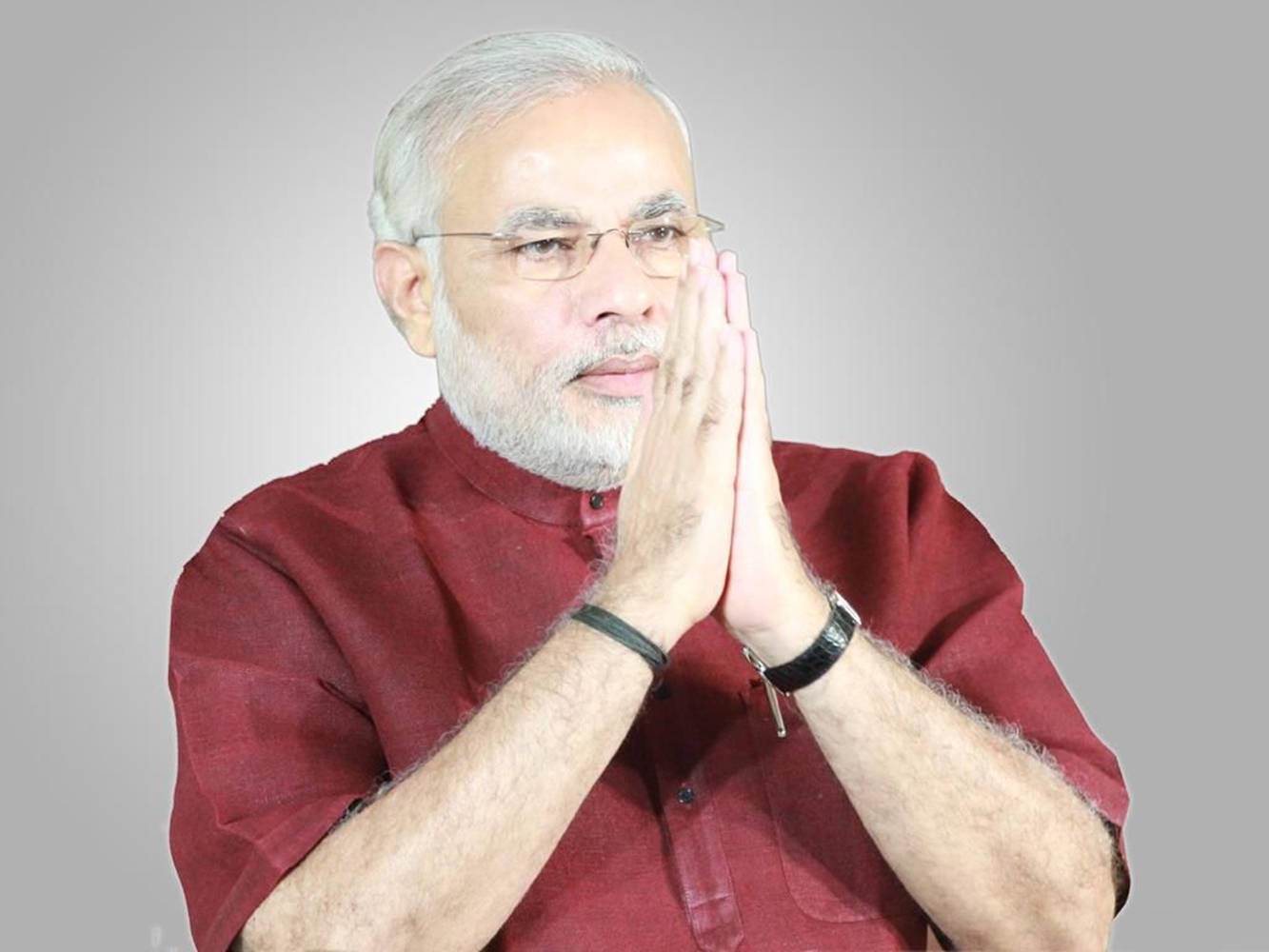 Narendra Modi 桌布 壁紙 — 一位戴眼鏡、留白鬍子的年長男士，身穿紅色庫爾塔，在純灰色背景前雙手合十，做出恭敬的姿勢。