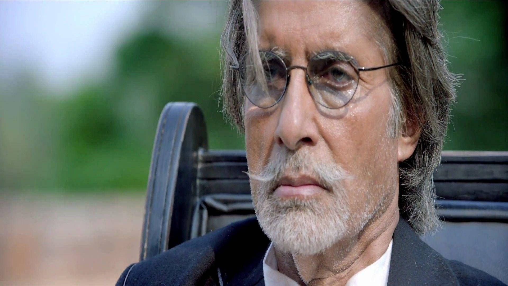 Amitabh Bachchan 桌布 壁紙 — 一位戴眼鏡、留白鬍子的成熟男性坐在戶外輪椅上的特寫。