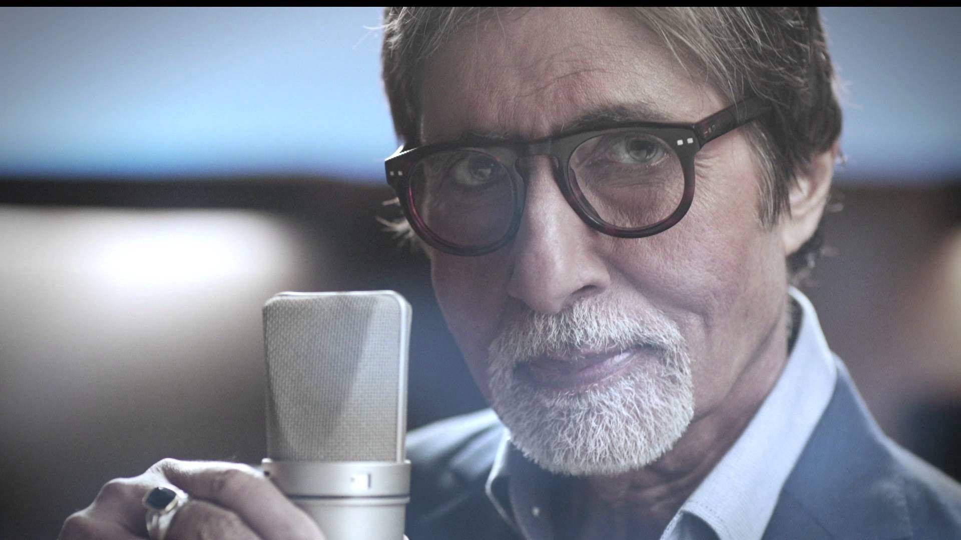Amitabh Bachchan 桌布 壁紙 — 一位戴眼鏡、留白鬍鬚的男人在錄音室中拿著復古麥克風的特寫。
