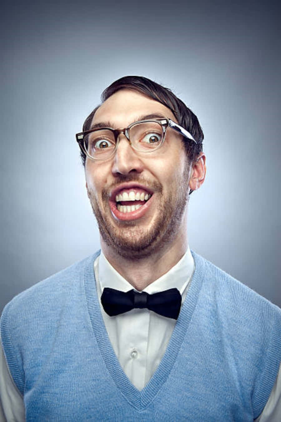 Nerd 桌布 壁紙 — 一位戴眼鏡和領結的男士在灰色工作室背景前咧嘴大笑。