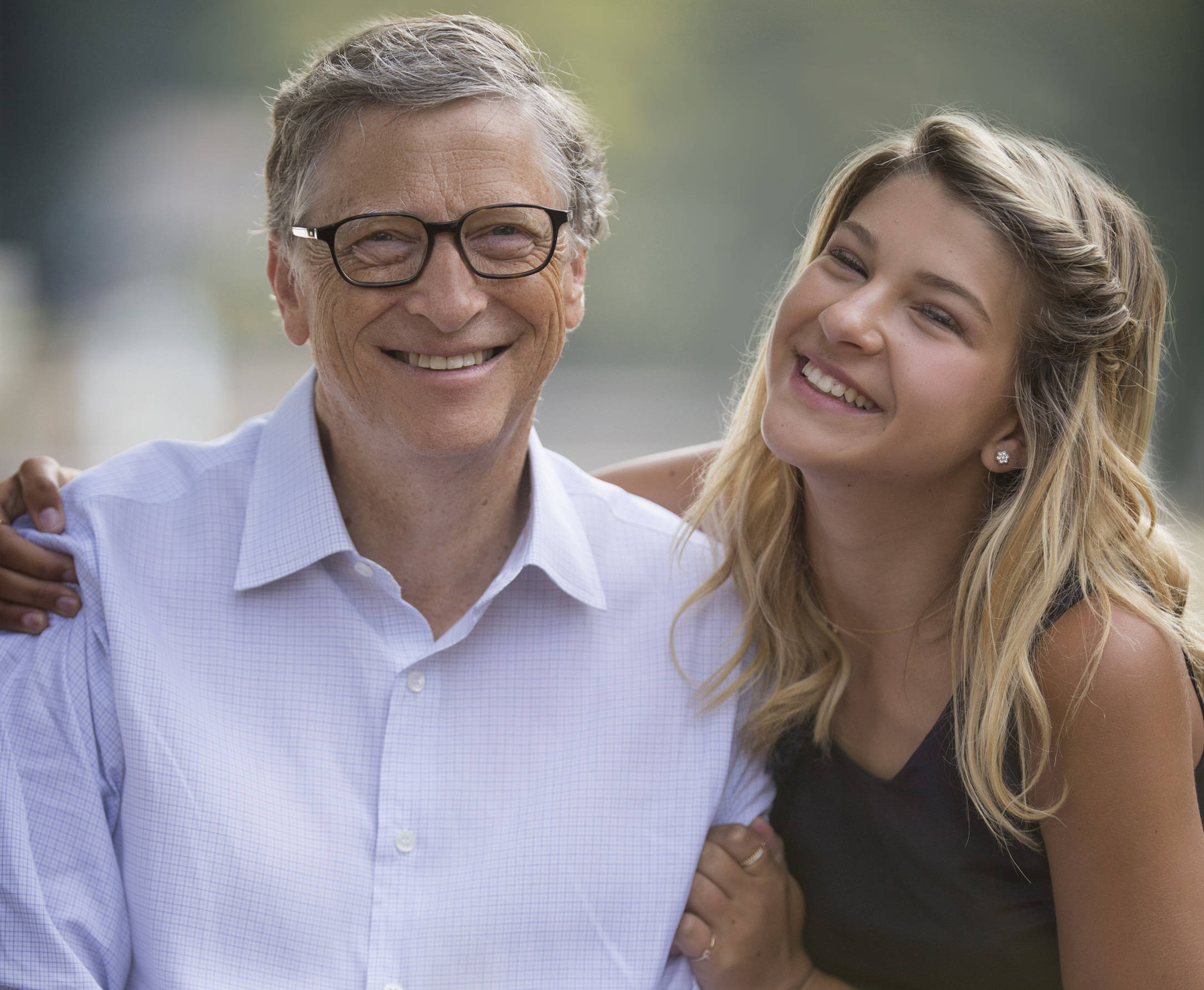 gates 桌布 壁紙 — 一位戴眼鏡微笑的老年男子和一位金髮年輕女子在戶外溫暖擁抱。