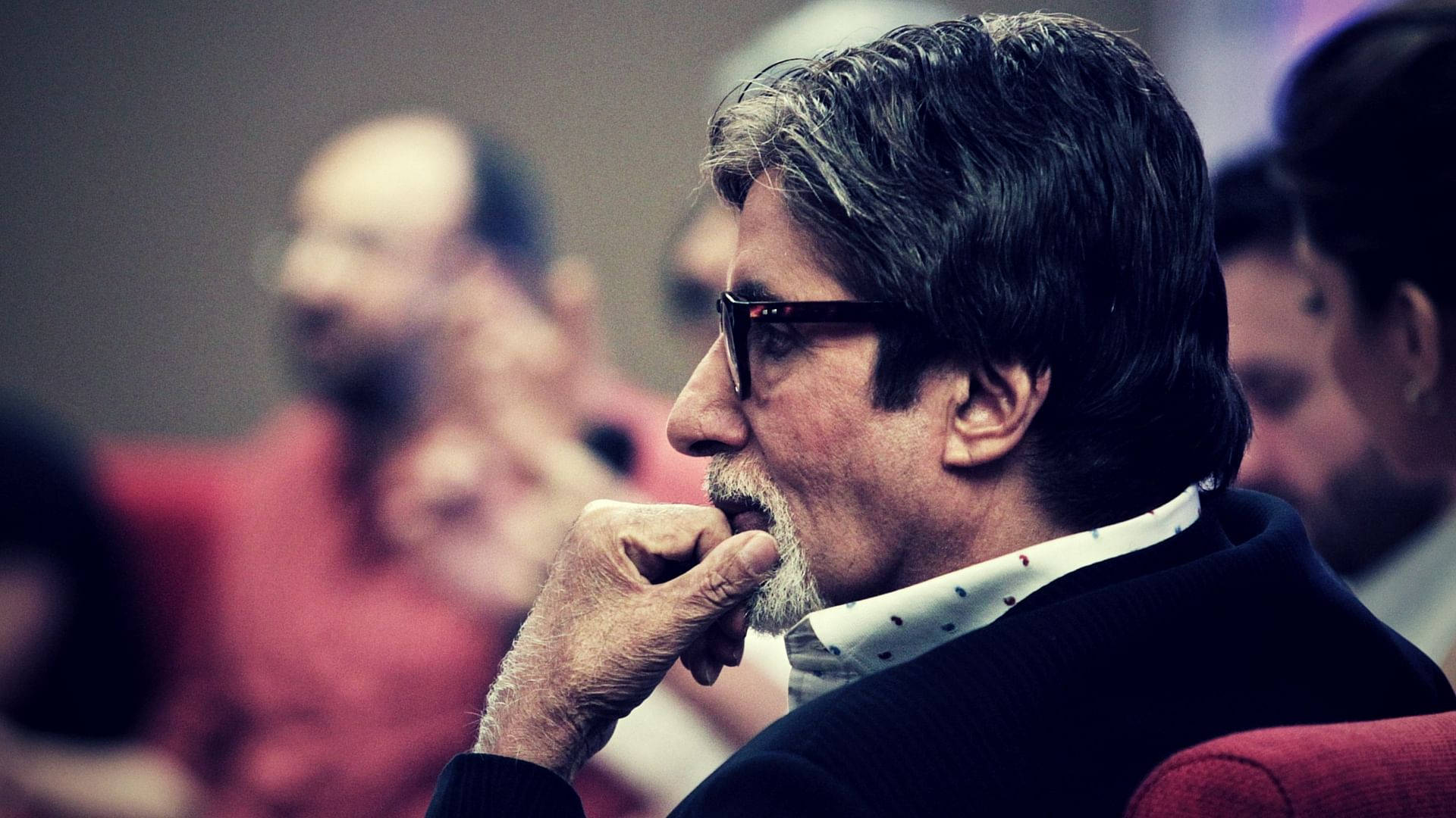 Amitabh Bachchan 桌布 壁紙 — 一位戴眼鏡留鬍鬚的男人側坐著，若有所思地摸著下巴，坐在一張紅色椅子上。