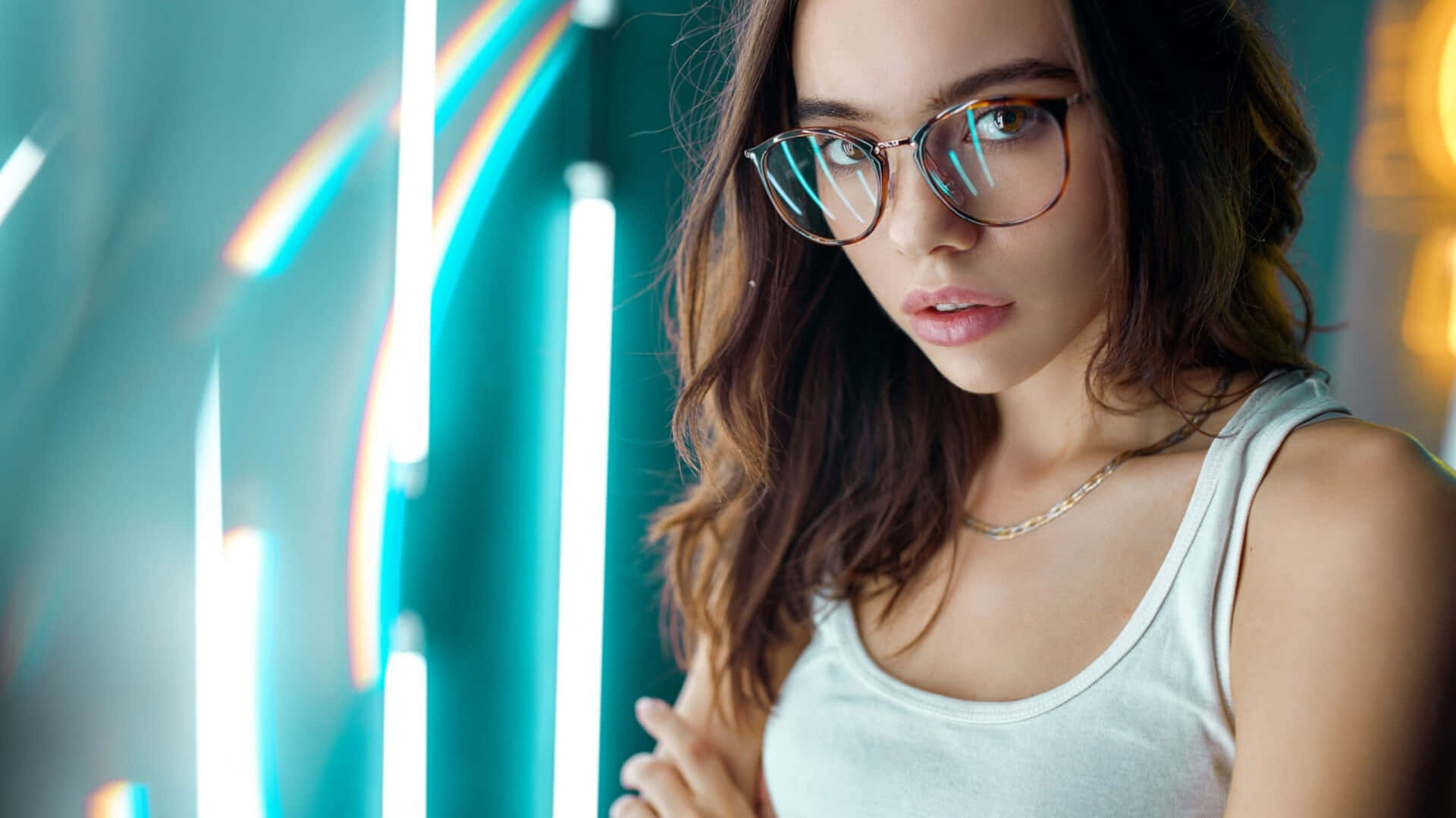 glasses 桌布 壁紙 — 一位戴眼鏡的年輕女性在充滿活力的霓虹燈背景下，凝視著彩虹色的光條。