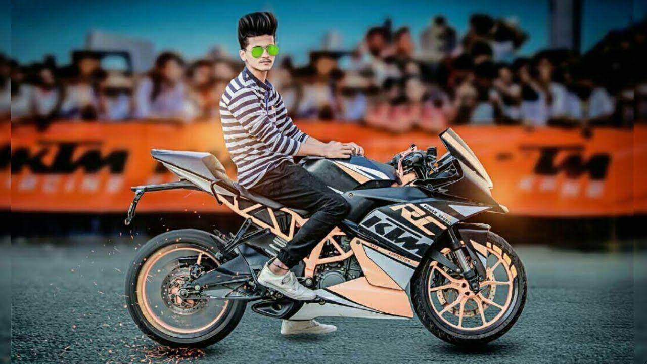 KTM 摩托車 桌布 壁紙 — 一位戴綠色太陽眼鏡和條紋襯衫的時尚男士，自信地在黑色和橙色的KTM機車上擺姿勢，背景是賽道上模糊的觀眾。
