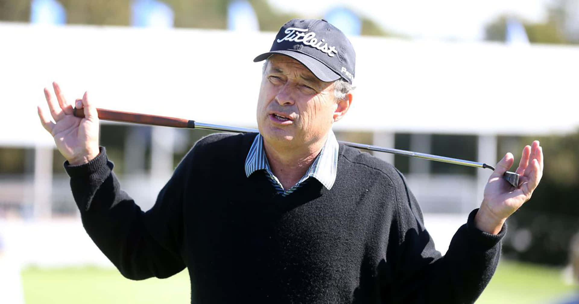 高爾夫 桌布 壁紙 — 一位戴著 Titleist 帽子的年長男士在晴朗的日子裡將高爾夫球桿扛在肩上。
