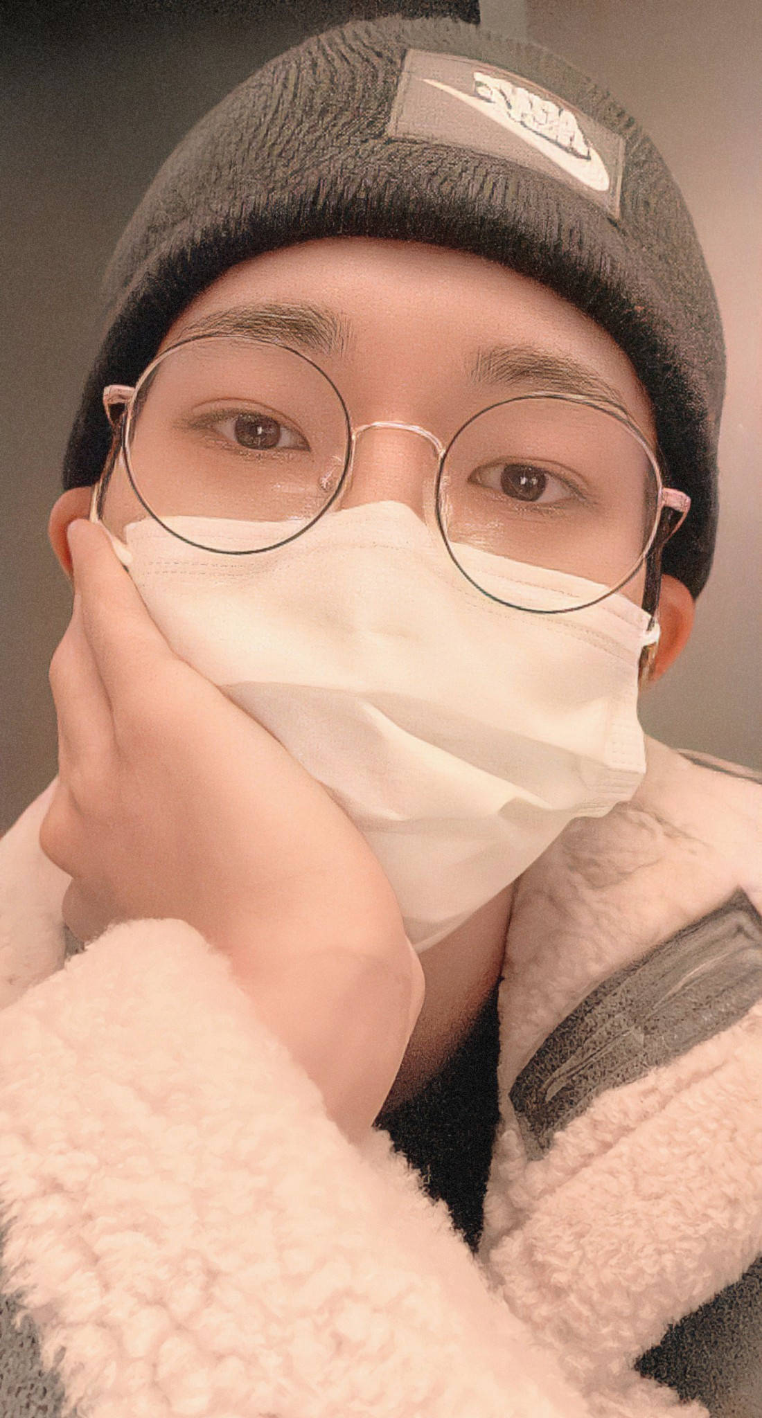 원우 桌布 壁紙 — 一位戴著圓框眼鏡和白色口罩的年輕人，托著下巴，身穿灰色毛帽和絨毛外套。