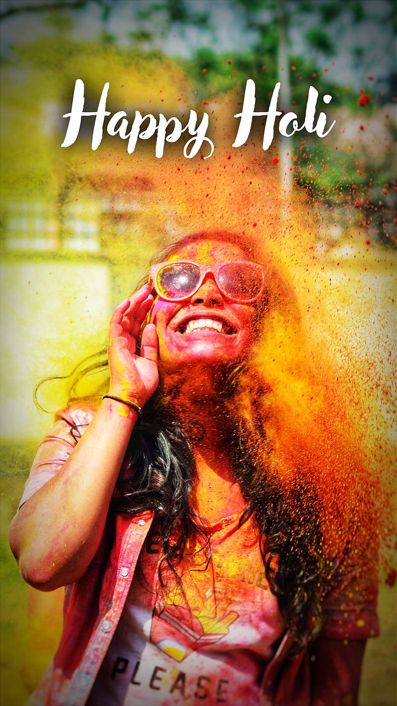 Holi 桌布 壁紙 — 一位戴著太陽眼鏡的快樂女性在灑紅節期間，彩色粉末在她周圍爆炸時大笑。