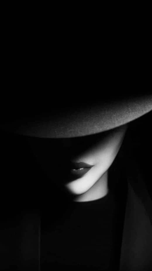 Woman 桌布 壁紙 — 一位戴著寬邊帽子的女性，在鮮明的黑白肖像中，臉上投下深深的陰影。
