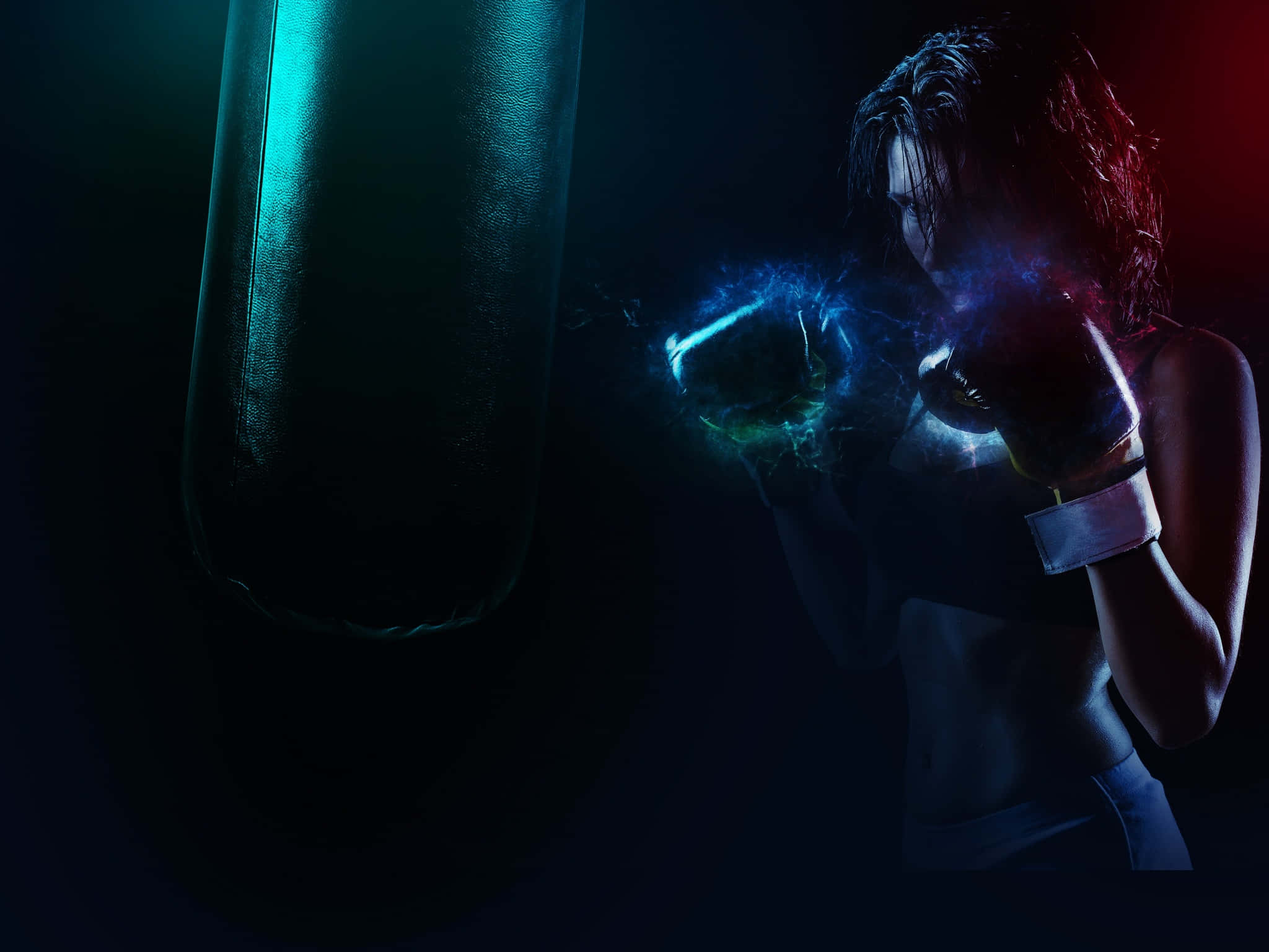 Boxing 桌布 壁紙 — 一位戴著手套的女拳擊手在戲劇性的藍色和紅色燈光下擊打發光的沙包。