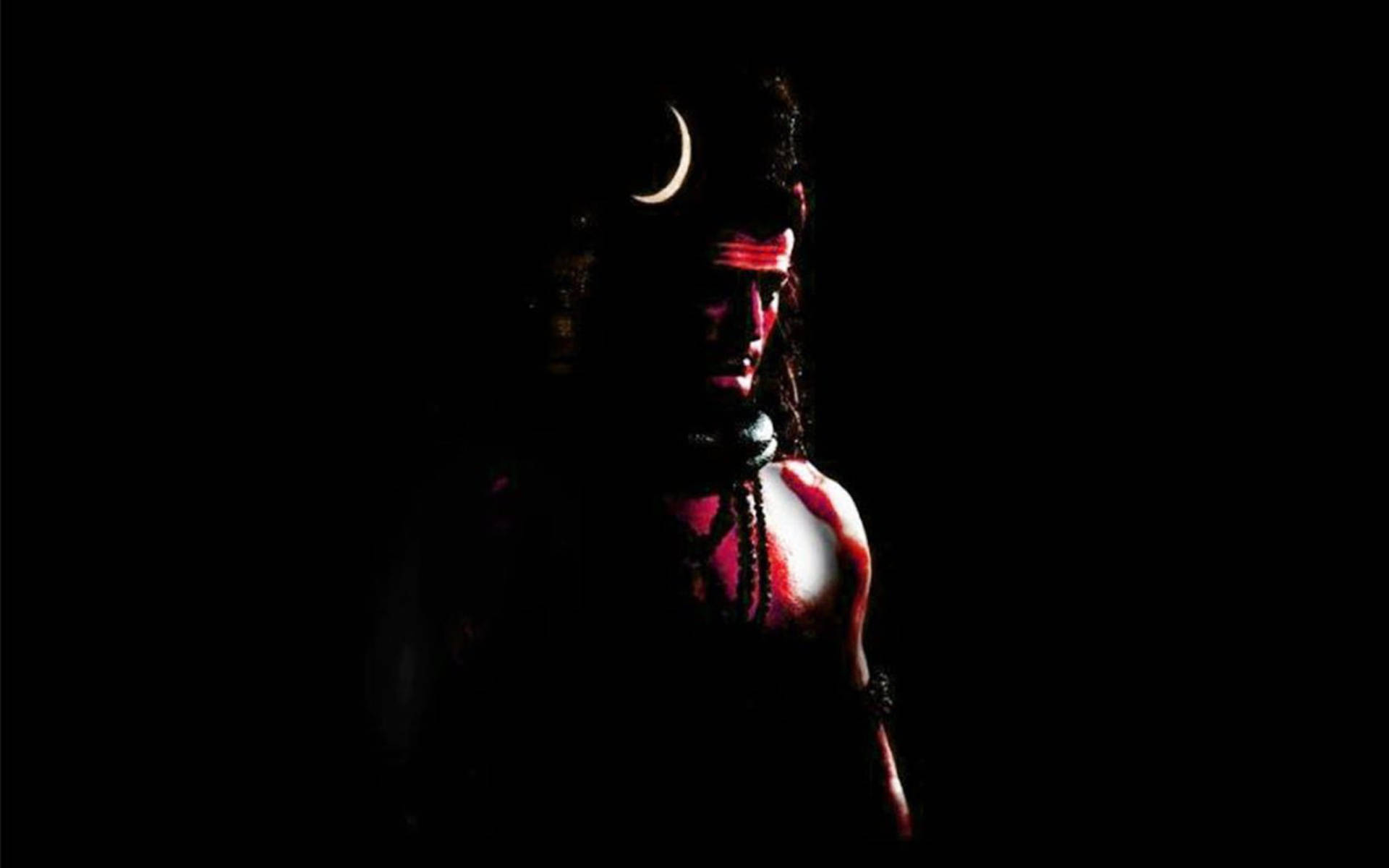 shiv shankar 桌布 壁紙 — 一位戴著新月冠冕和紅色標記的神祇的黑暗剪影，在黑色虛空中隱約發光。