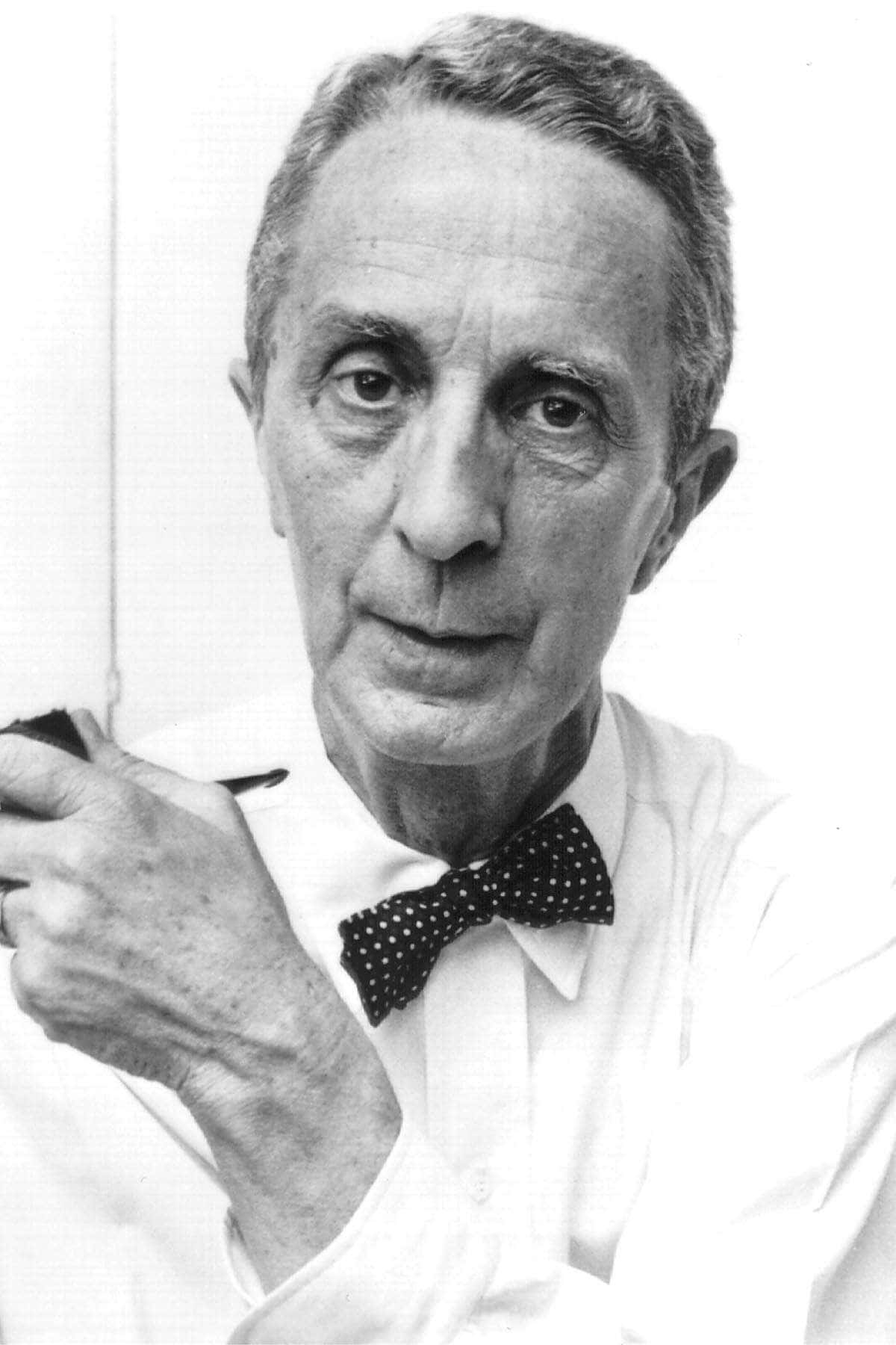Norman Rockwell 桌布 壁紙 — 一位戴著波點蝴蝶結、手持煙斗的長者黑白肖像，背景簡潔。