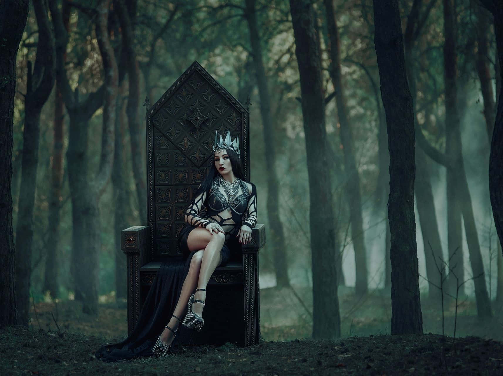 Dark Queen 桌布 壁紙 — 一位戴著王冠、身穿黑色禮服的女士，端坐在霧氣瀰漫、陰暗森林中的華麗王座上。
