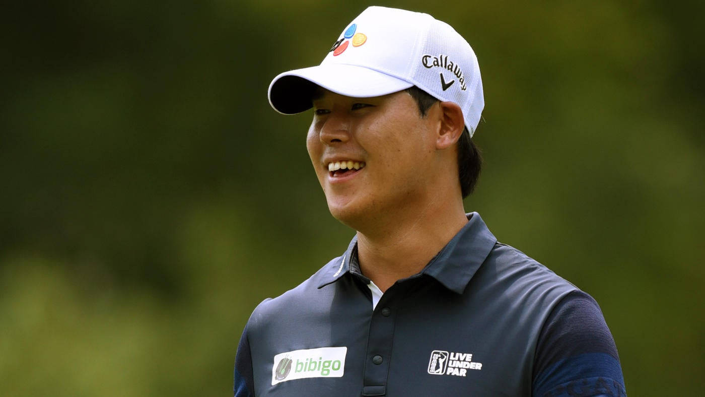 smiling 桌布 壁紙 — 一位戴著白色 Callaway 帽子和深色 Polo 衫的高爾夫球手微笑著站在模糊的綠色背景前。