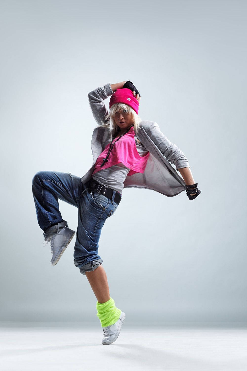 dancer 桌布 壁紙 — 一位戴著粉紅色毛帽和螢光襪的動感舞者，在純色工作室背景前擺出充滿活力的嘻哈姿勢。