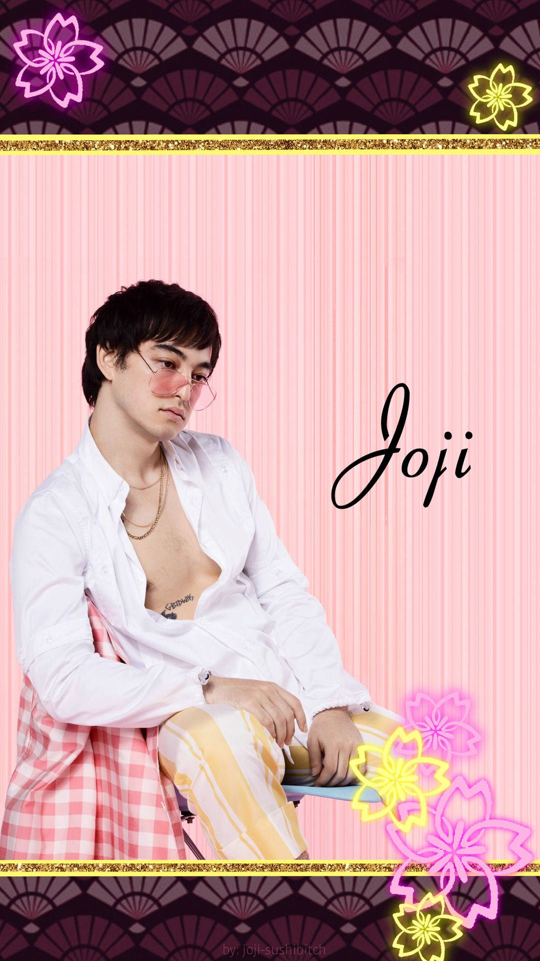 joji 桌布 壁紙 — 一位戴著粉紅色眼鏡的時尚男士坐在粉紅色條紋背景前，背景飾有發光花卉圖案和扇子圖案。