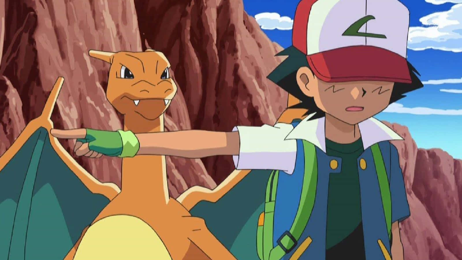 Charizard Pokemon 桌布 壁紙 — 一位戴著紅白帽子的年輕訓練家，在岩石峭壁間，蔚藍天空下，指向前方，旁邊是他的橙色龍系寶可夢。
