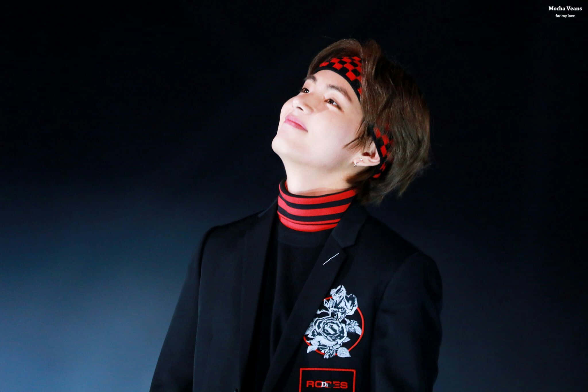 Taehyung Cute 桌布 壁紙 — 一位戴著紅色格子頭帶的年輕男子，在柔和藍光照亮的黑暗工作室中向上凝視。