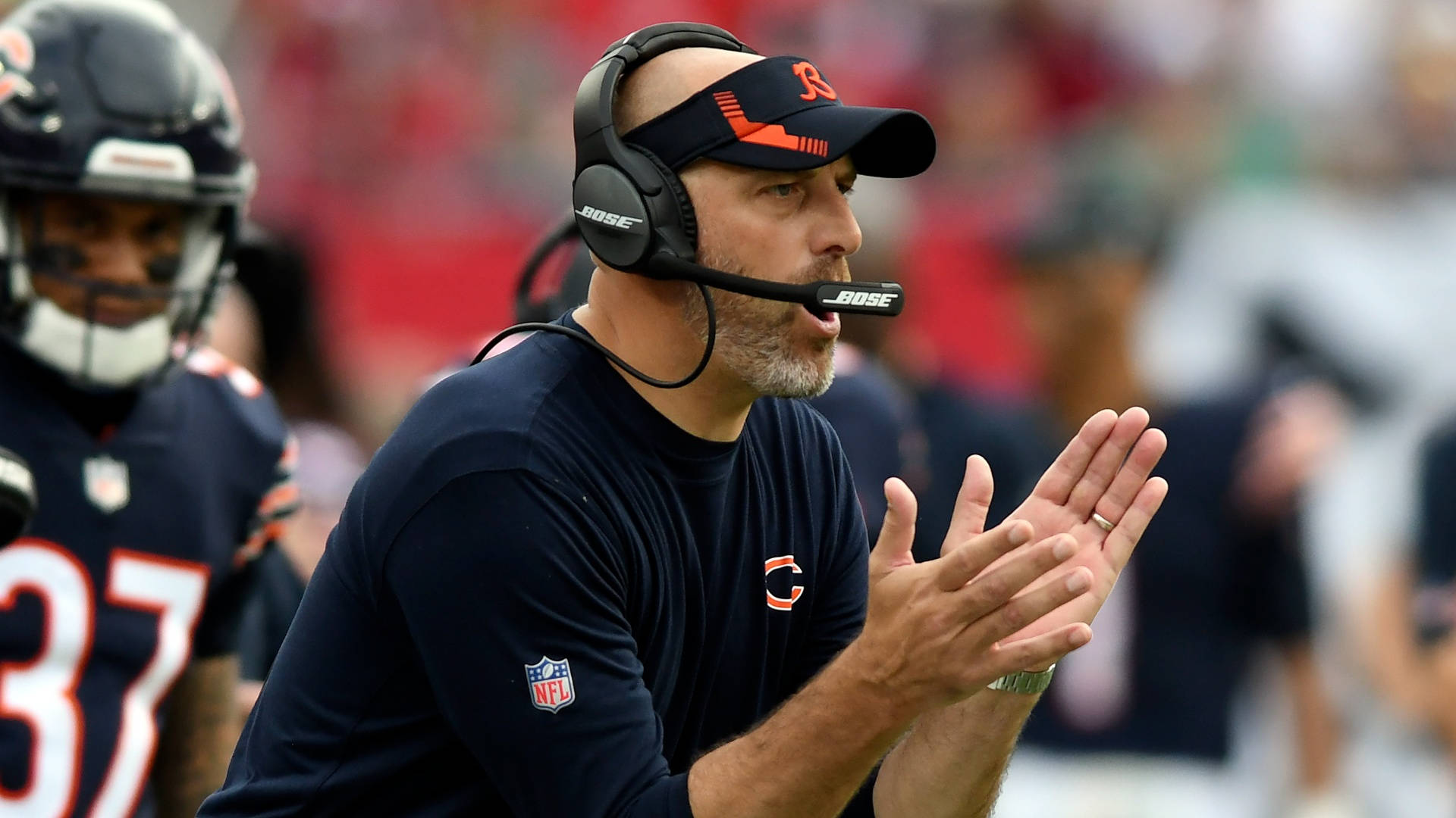 Coach 桌布 壁紙 — 一位戴著耳機的芝加哥熊隊教練在日間NFL比賽期間在邊線專注地拍手。