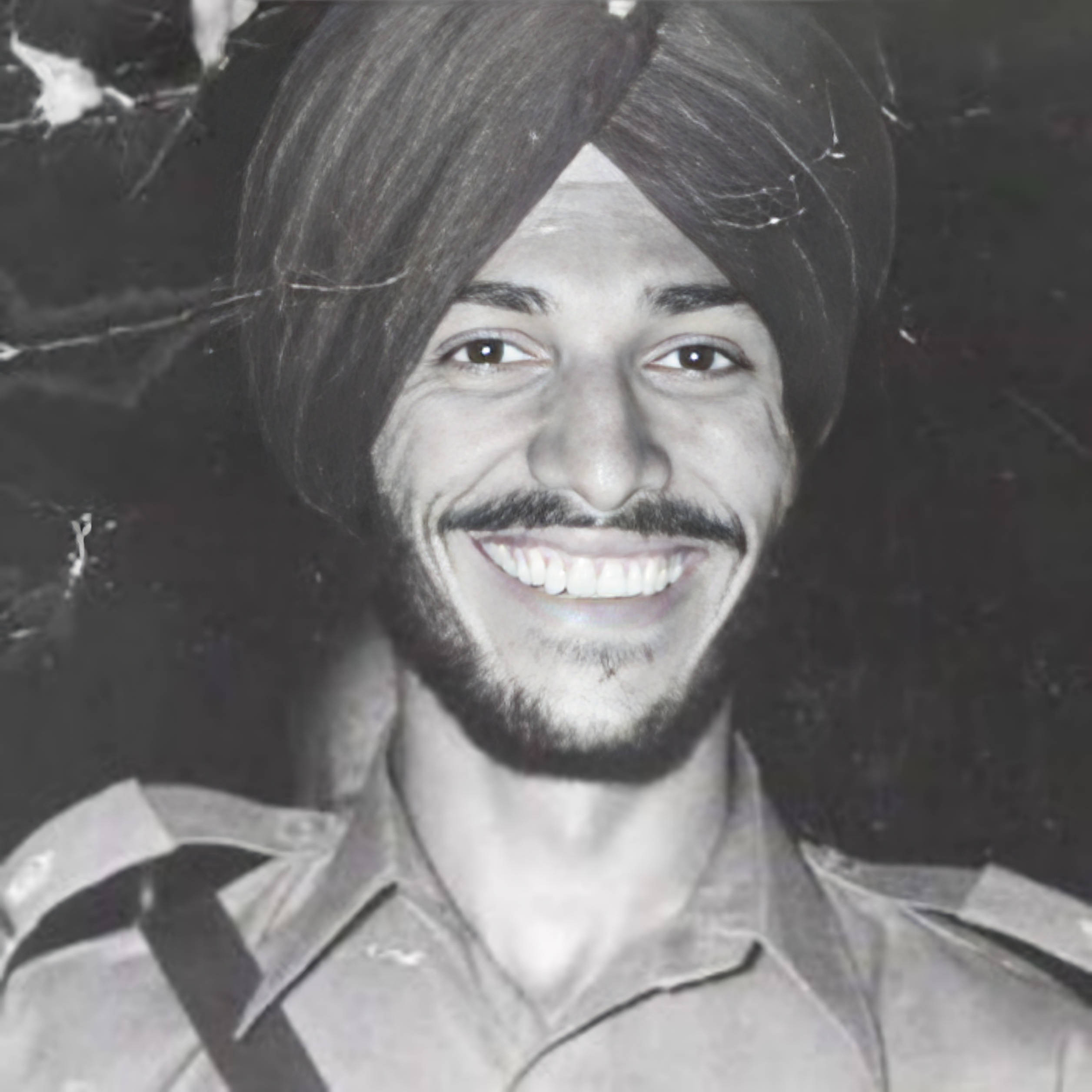 Milkha Singh 桌布 壁紙 — 一位戴著頭巾的快樂男子在帶有裂紋底片質感的復古黑白肖像中閃耀著光芒。