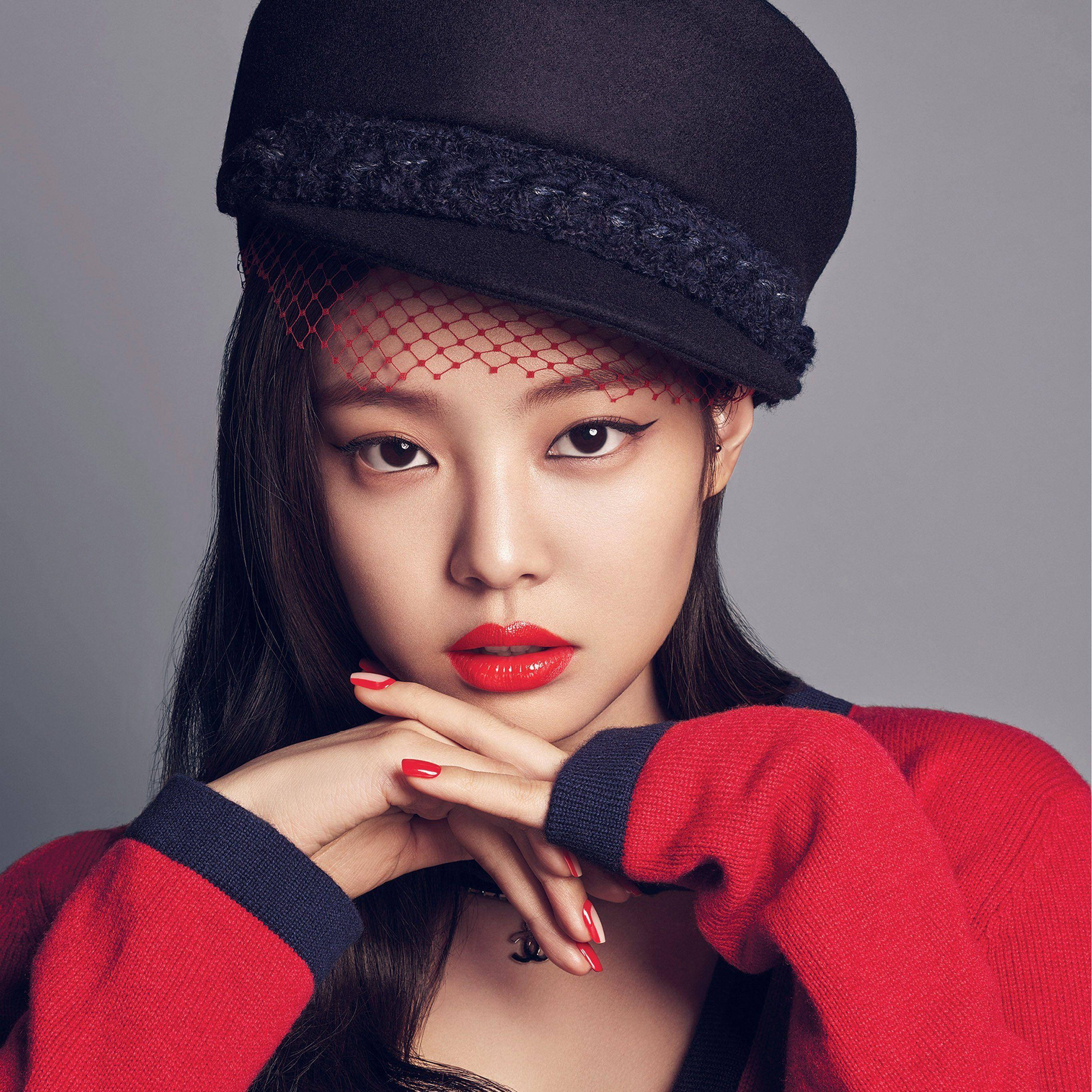Jennie 桌布 壁紙 — 一位戴著黑色帽子、紅色網紗和鮮豔紅唇的女性，在灰色攝影棚背景前，雙手交疊放在下巴下方擺姿勢。