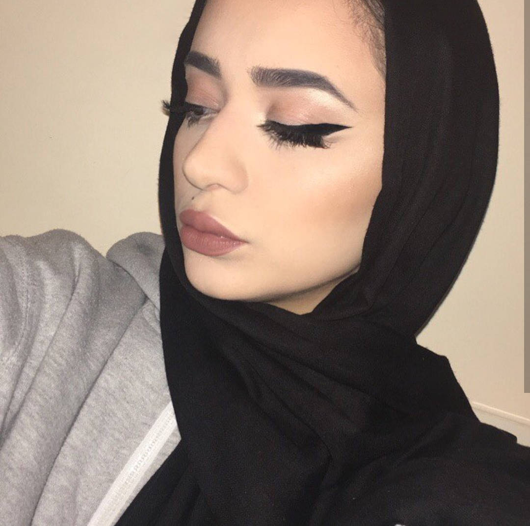 muslim 桌布 壁紙 — 一位戴著黑色頭巾和粗黑翼狀眼線的女性，神情平靜地向下凝視。