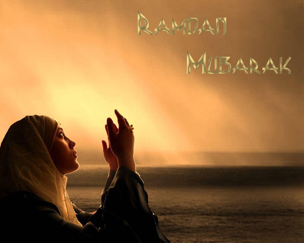 Ramadan 桌布 壁紙 — 一位戴頭巾的女性在金色日落映照水面的背景下舉手祈禱，帶有「Ramadan Mubarak」文字。