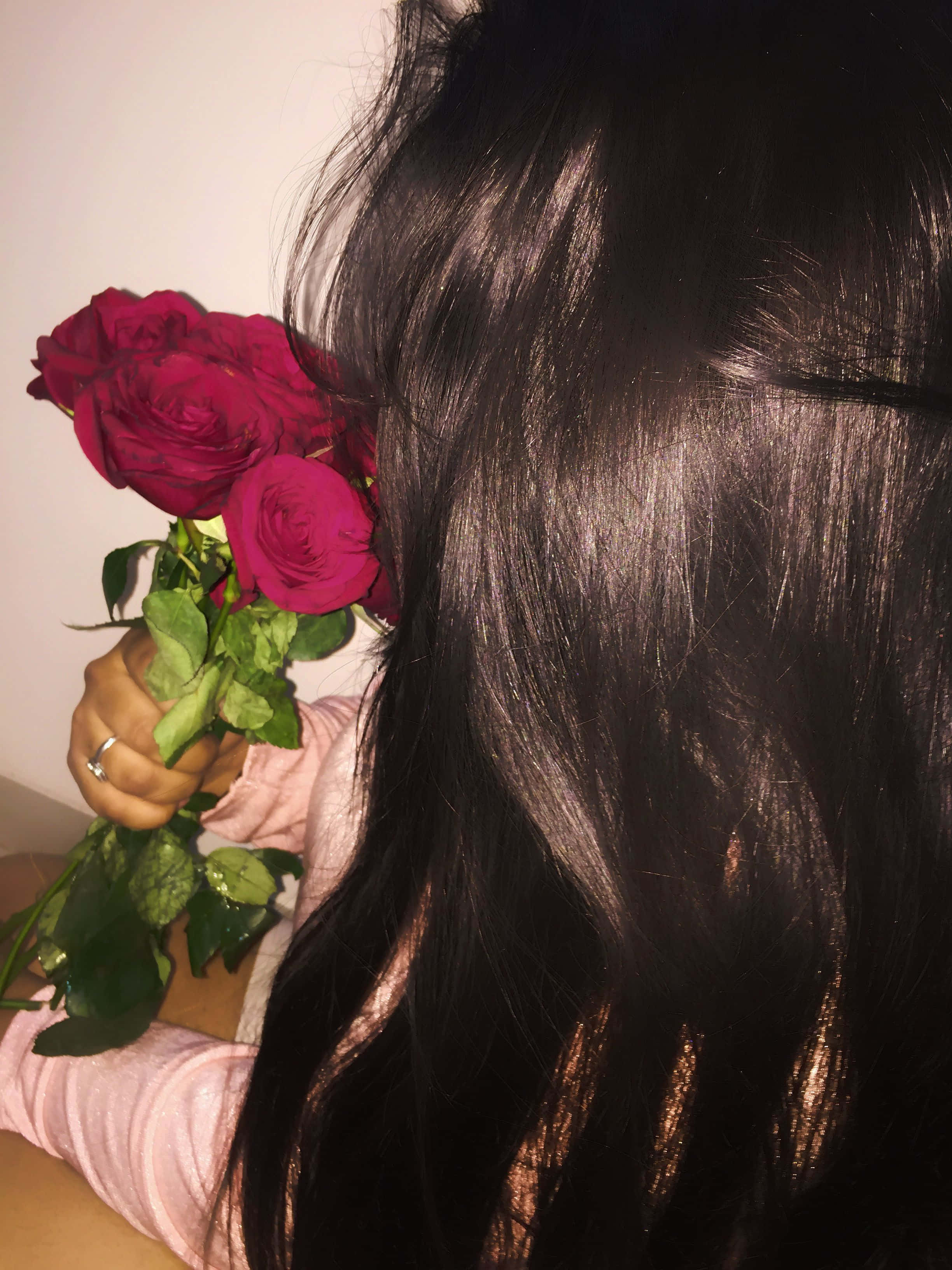 一位手持玫瑰花束的女性 壁紙