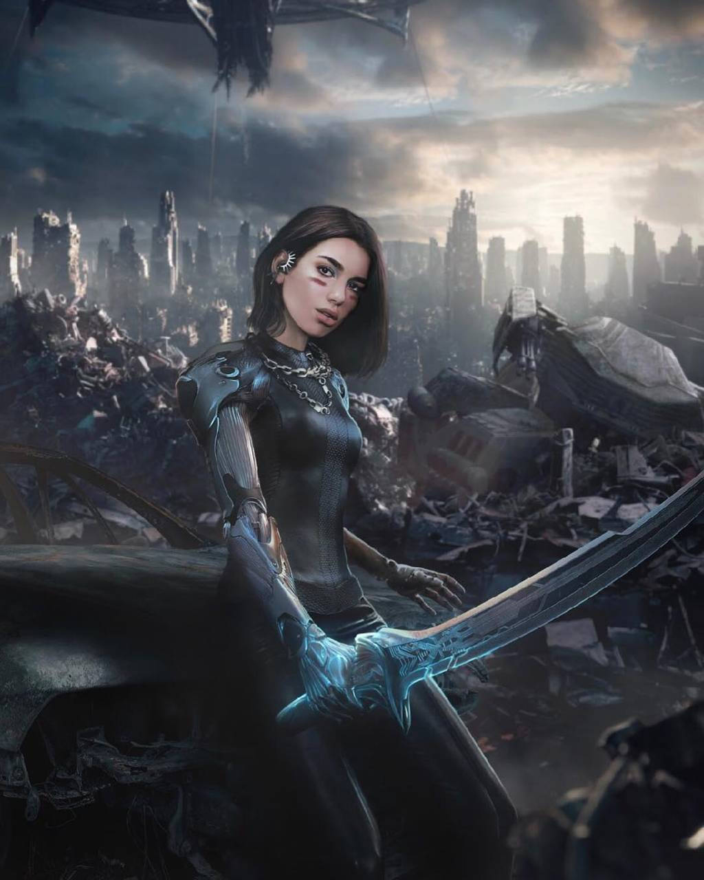 Alita 桌布 壁紙 — 一位手持發光藍色劍的女戰士，在風暴天空下，傲然站立於廢墟般的未來城市景觀中。