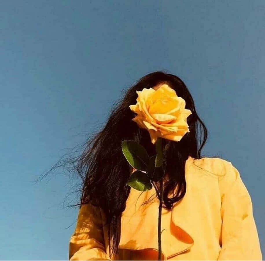 一位手持黃玫瑰的女性 壁紙