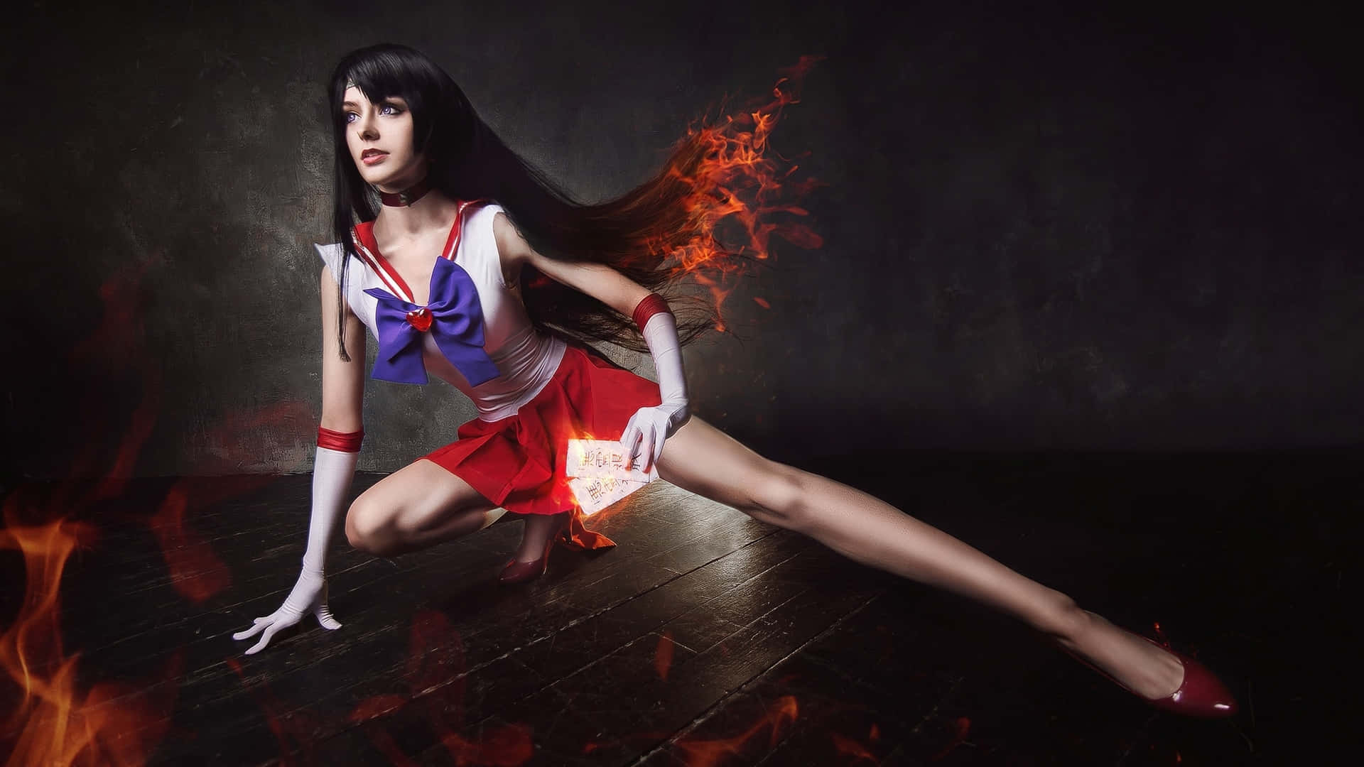 sailor mars 桌布 壁紙 — 一位扮演水手火星的角色扮演者，在黑暗背景下擺出動感姿勢，火焰從她手中噴出並流過她的頭髮。
