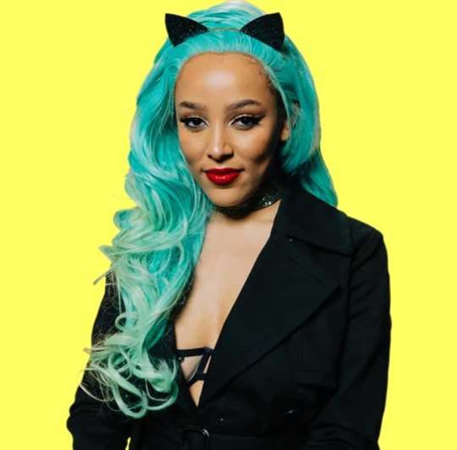 Doja Cat 桌布 壁紙 — 一位擁有充滿活力的藍綠色頭髮和黑色貓耳的女性，在明亮的黃色背景前自信地擺姿勢。