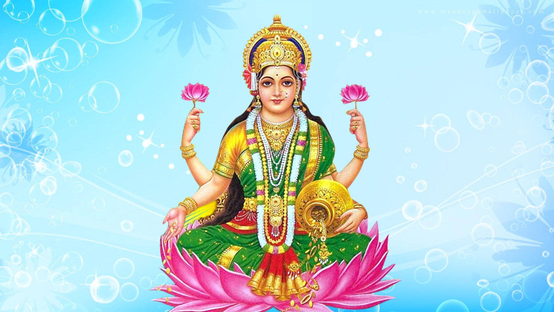 Lakshmi 桌布 壁紙 — 一位擁有四臂的神聖女神優雅地坐在粉紅色蓮花上，手持粉紅色蓮花，背景是閃閃發光的藍色。