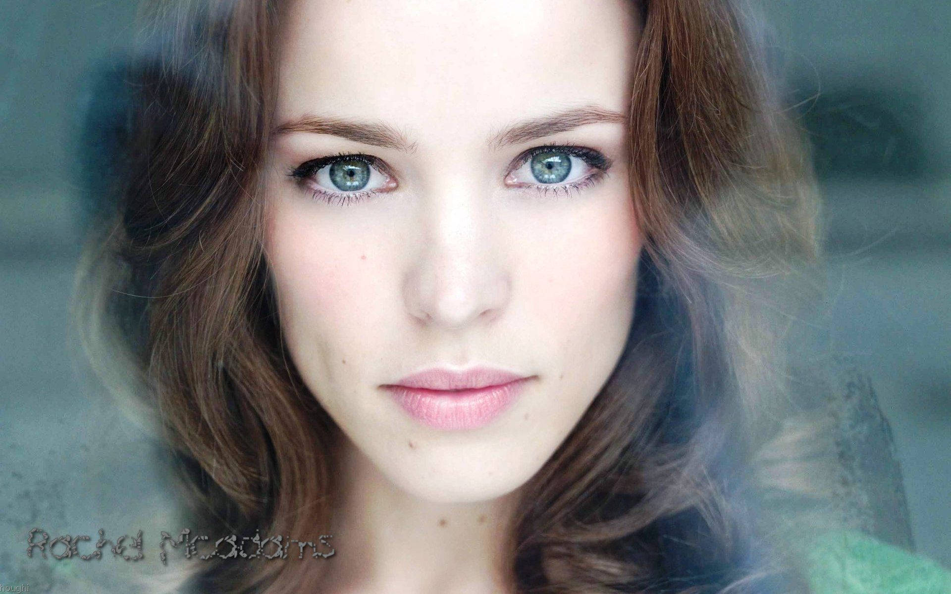 Rachel Mcadams 桌布 壁紙 — 一位擁有引人注目的藍色眼睛和柔軟棕色頭髮的女性，透過模糊的玻璃表面直視鏡頭的近距離肖像。