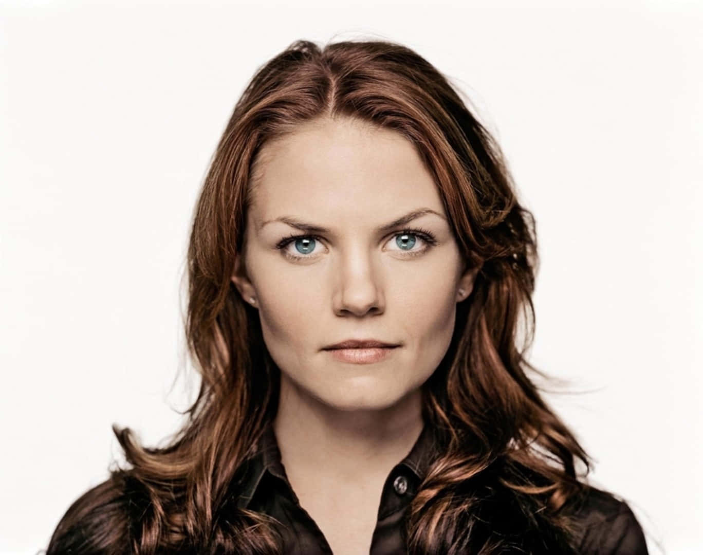 jennifer morrison 桌布 壁紙 — 一位擁有引人注目的藍色眼睛和波浪棕色頭髮的女性，在純白色背景前凝視著。
