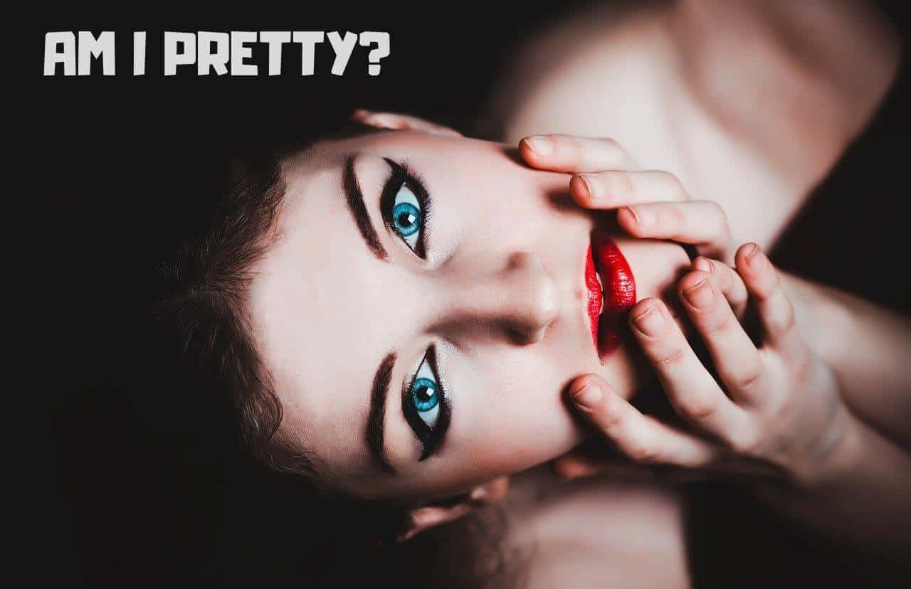 Pretty Aesthetic Computer 桌布 壁紙 — 一位擁有引人注目的藍色眼睛和紅色嘴唇的女性，在黑暗背景上帶有粗體文字「AM I PRETTY?」的情況下，用手遮住嘴巴直視鏡頭。