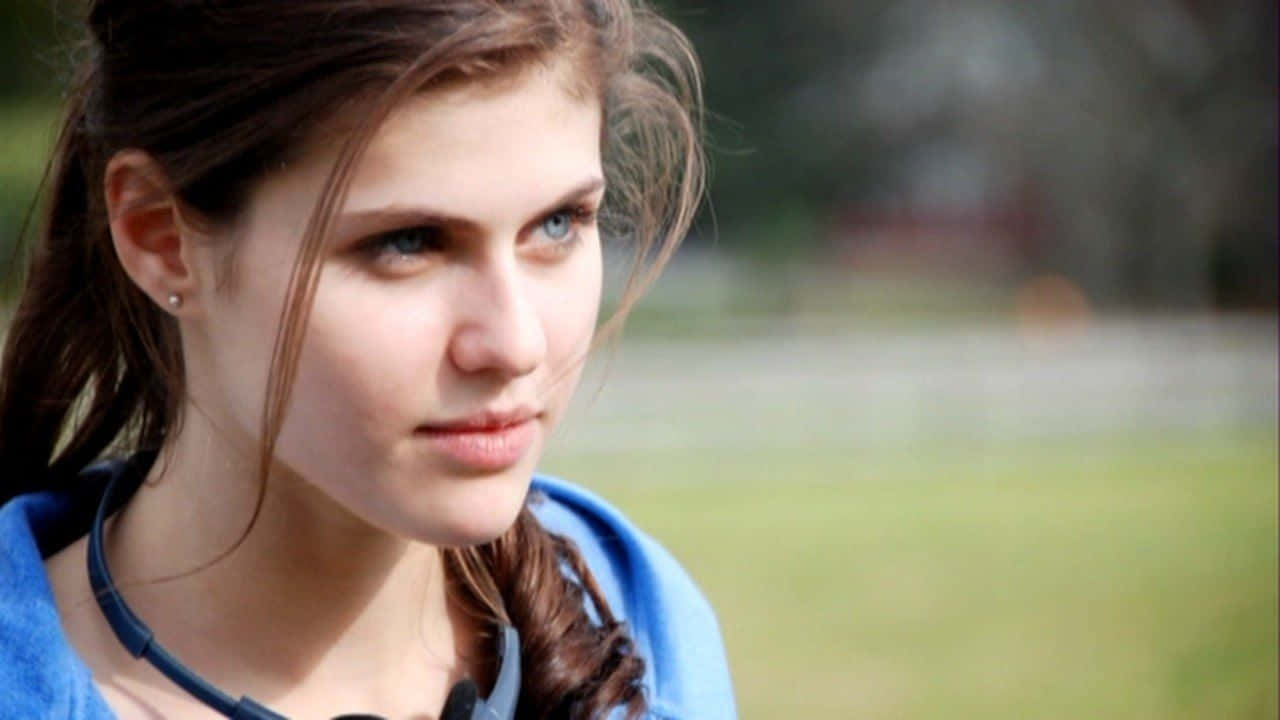 Alexandra Daddario 桌布 壁紙 — 一位擁有引人注目藍眼睛的年輕女性，在柔和的自然光線下若有所思地凝視戶外。