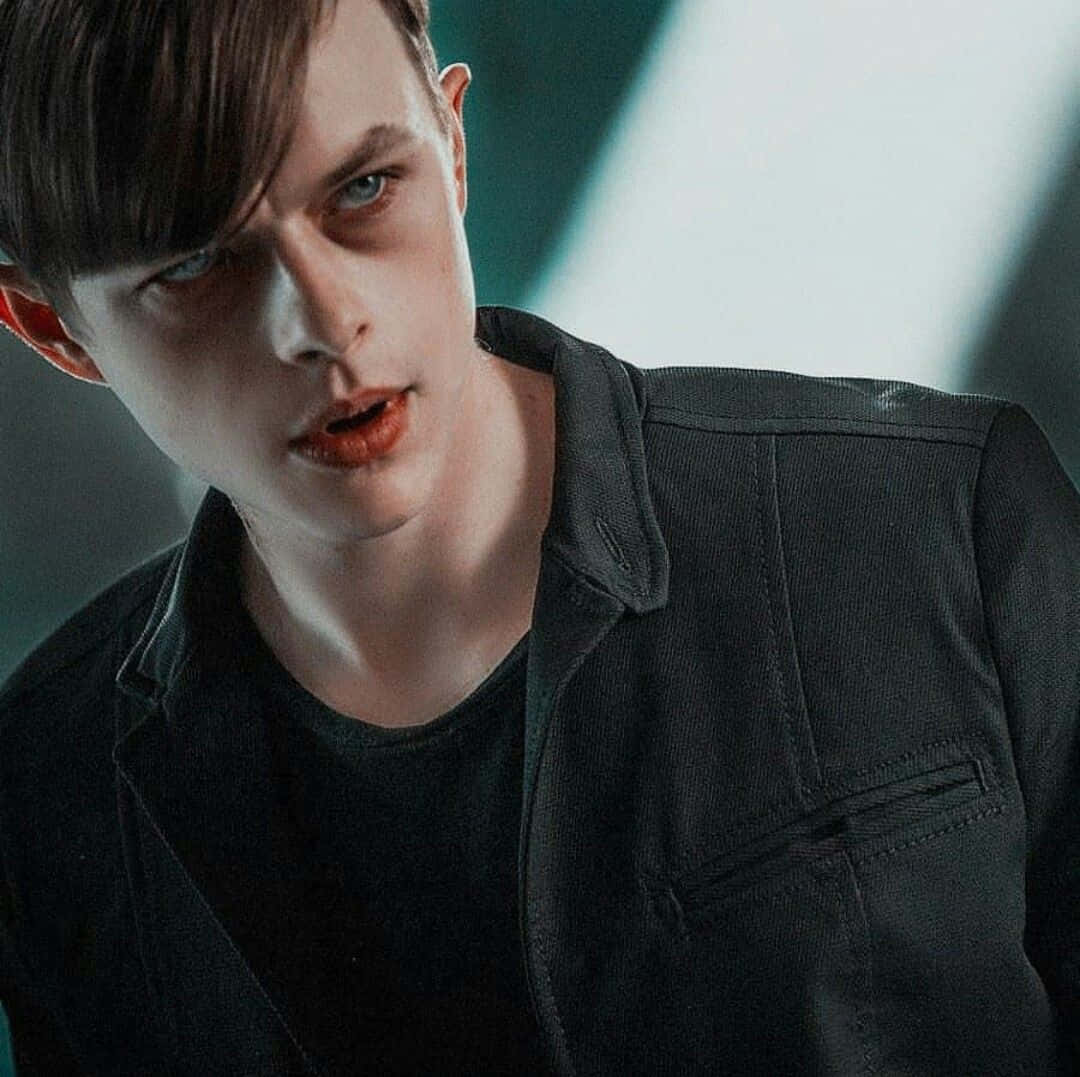 Harry Osborn 桌布 壁紙 — 一位擁有強烈藍色眼睛和深色頭髮的年輕男子，在昏暗的燈光下直視鏡頭。