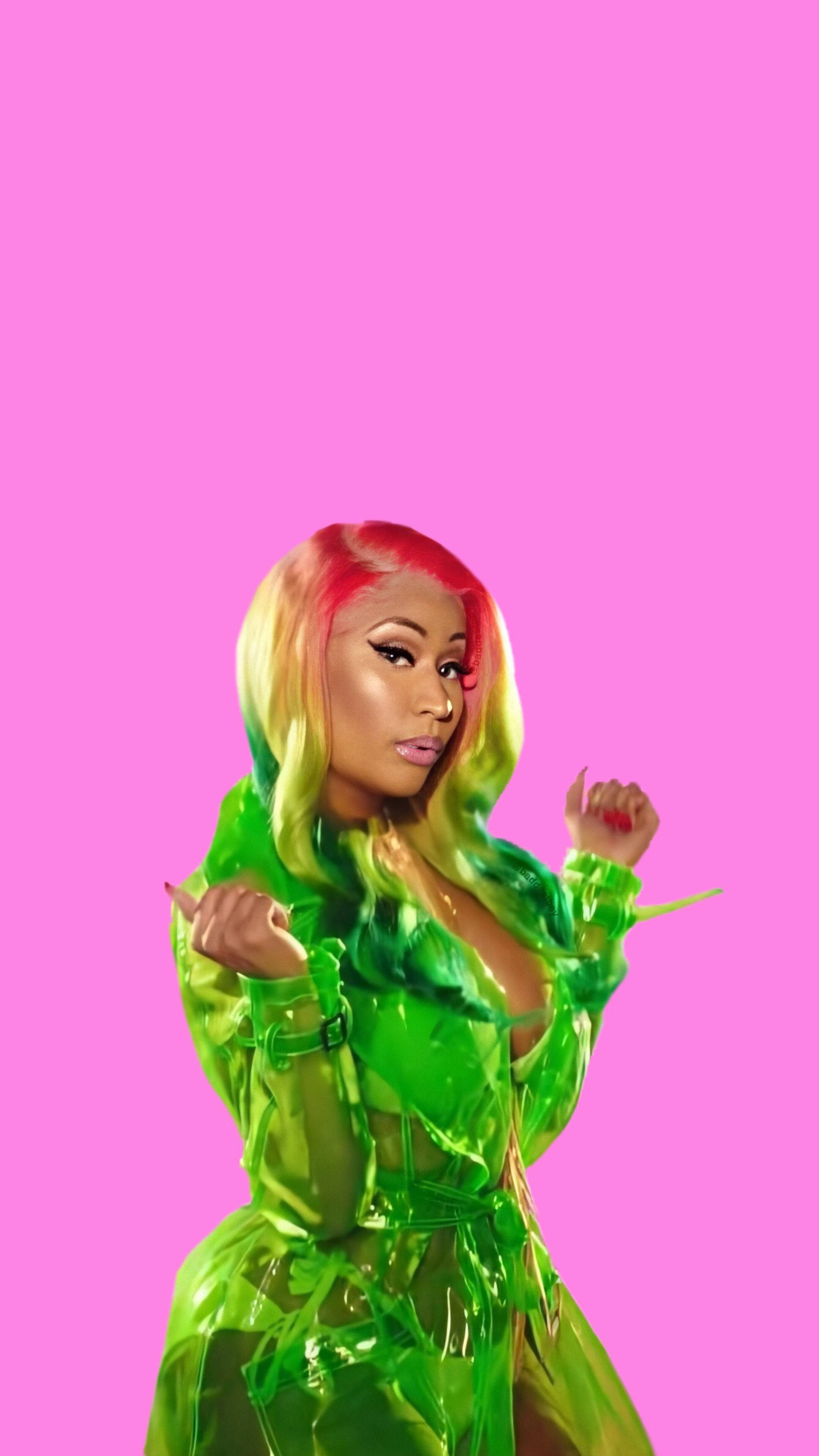 Nicki 桌布 壁紙 — 一位擁有彩虹色頭髮的女性，穿著閃亮的綠色服裝，背景為純粉色。