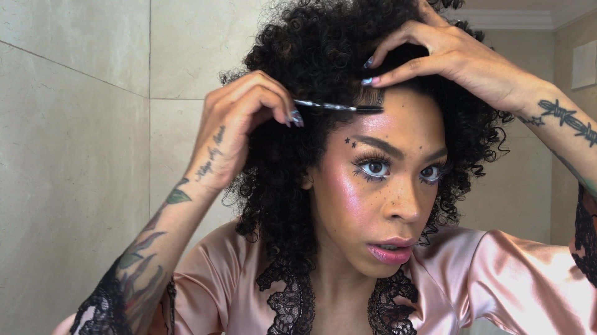 Rico Nasty 桌布 壁紙 — 一位擁有捲髮和刺青的女性，穿著緞面睡袍，用梳子梳理頭髮。