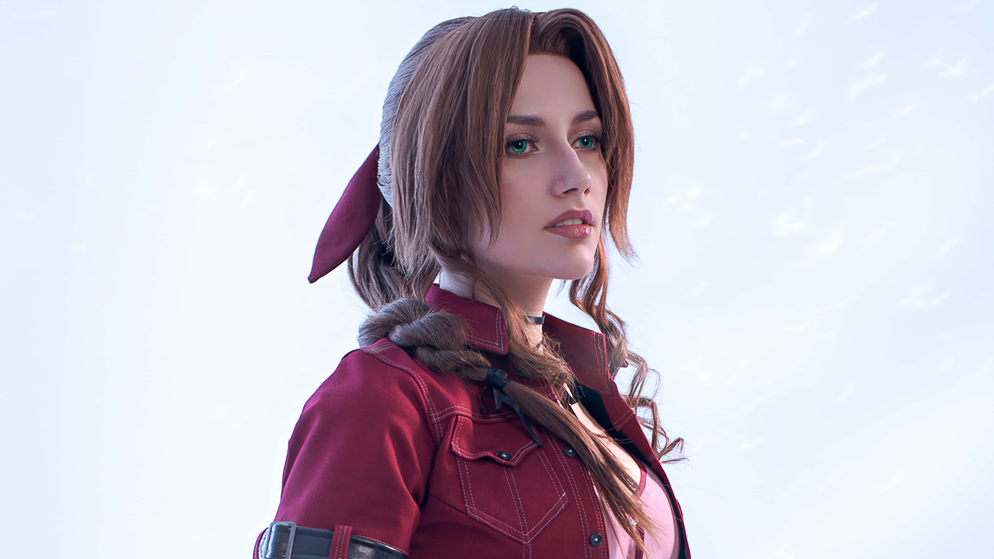 PlayStation 桌布 壁紙 — 一位擁有棕色辮子頭髮和綠色眼睛的女性，在雪景背景下穿著紅色外套。