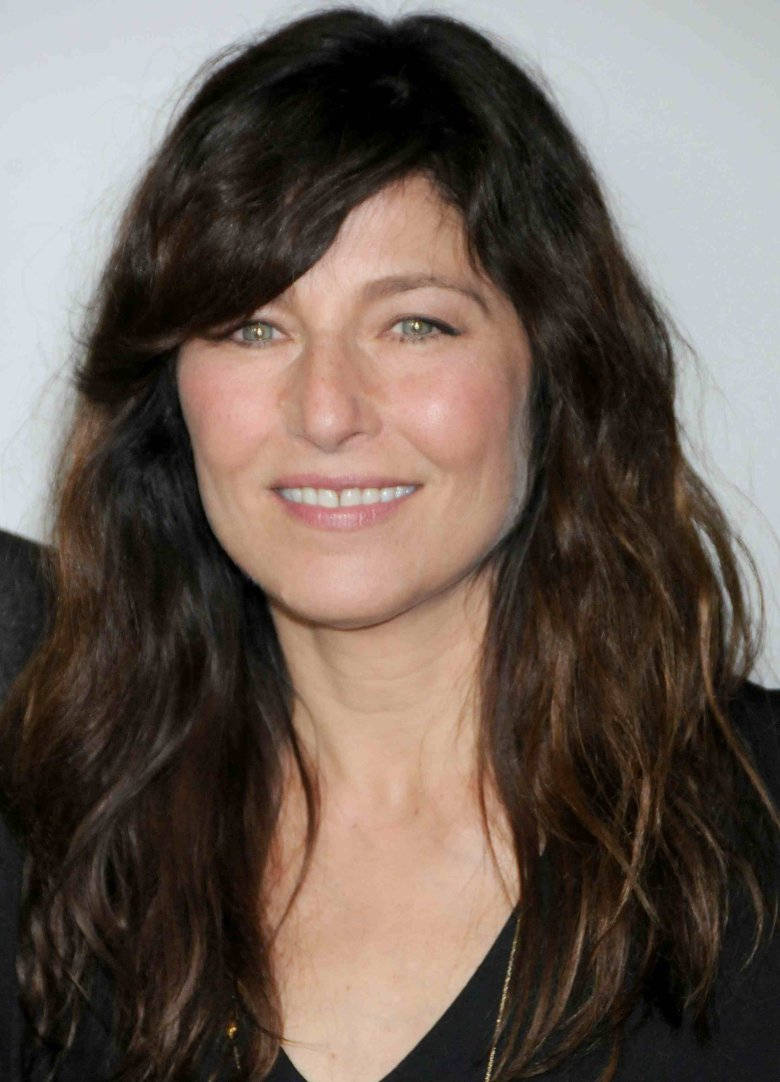 Celebrity 桌布 壁紙 — 一位擁有波浪深棕色頭髮的女性在純白色背景前溫暖微笑的特寫肖像。